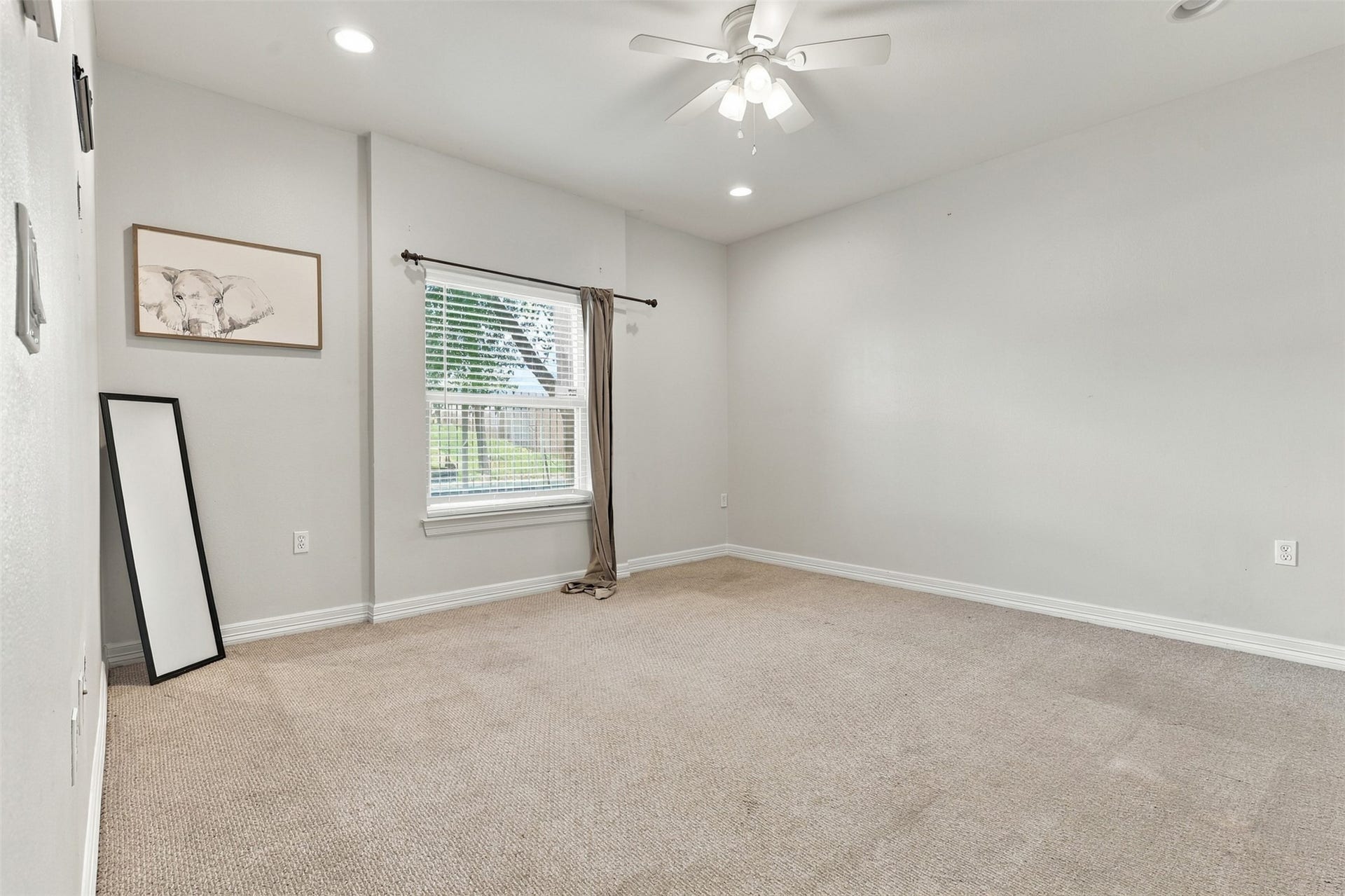 3501 Chenevert Street, #3, Houston, TX 77004 Spacious room with neutral tones, featuring plush carpet, a ceiling fan, and ample natural light from the large window.