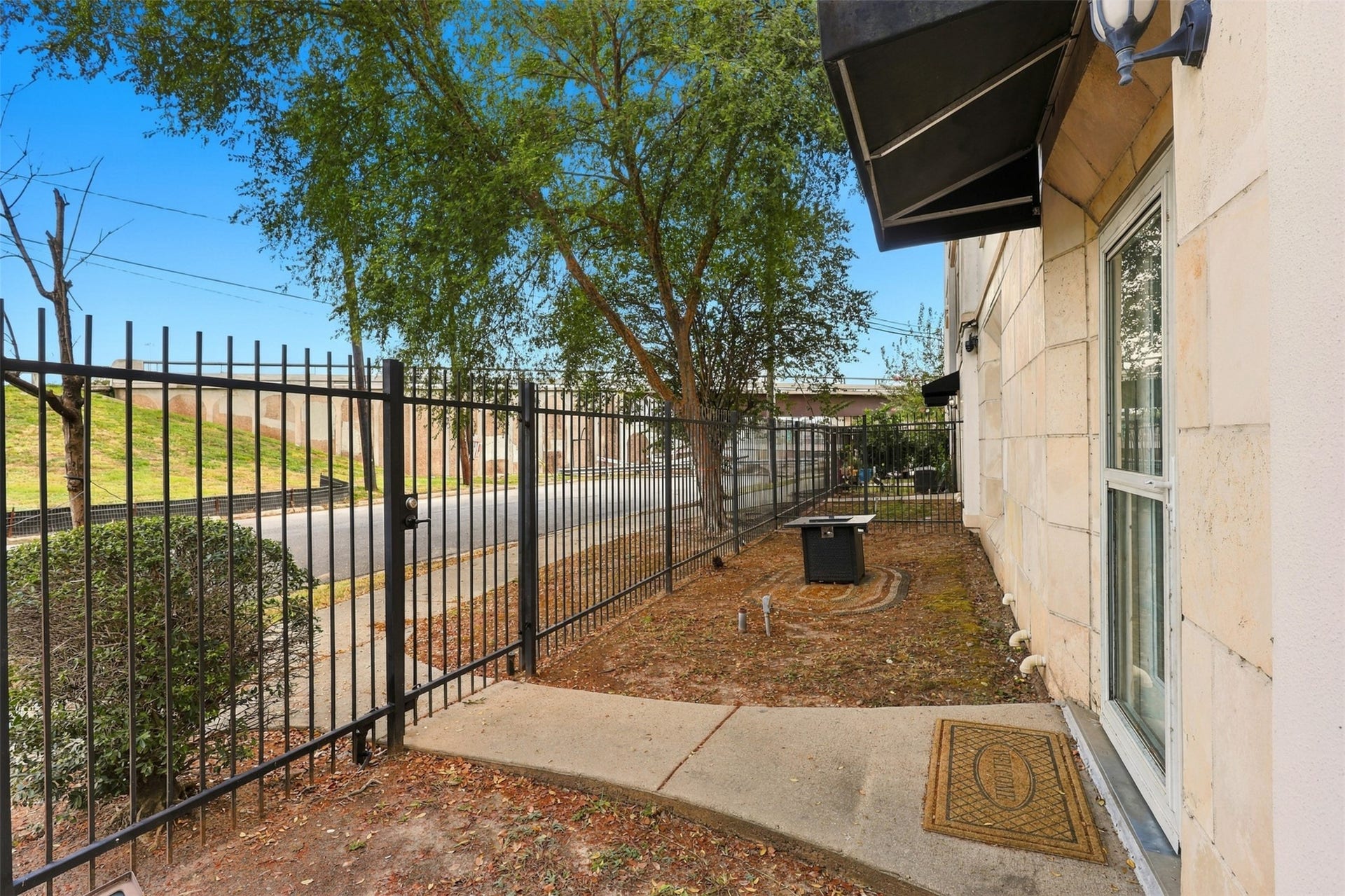 3501 Chenevert Street, #3, Houston, TX 77004 Charming fenced side yard with mature trees, offering privacy and a welcoming entryway.
