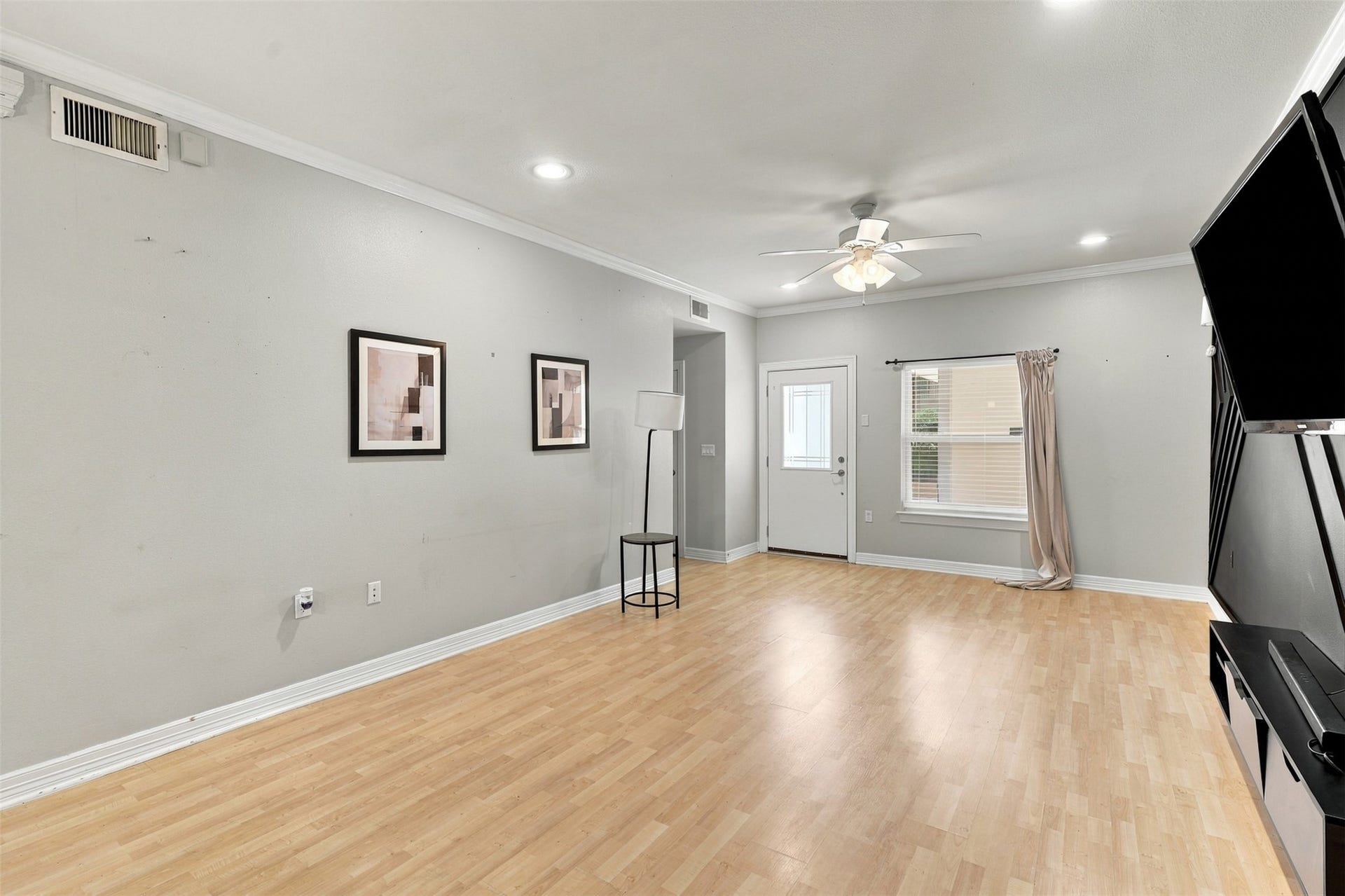 3501 Chenevert Street, #3, Houston, TX 77004 Spacious living area with light wood flooring, neutral walls, and abundant natural light from a large window. The ceiling fan and recessed lighting add modern comfort.