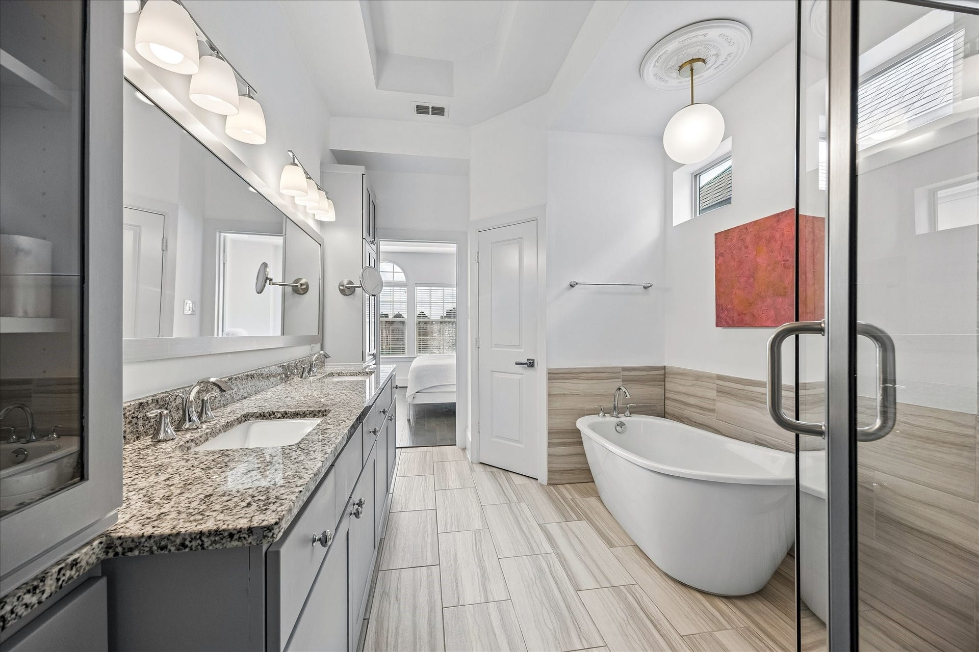 Another perspective of the spacious primary bath showcasing oversized soaking tub & separate walk-in shower! Thoughtfully designed w/ private water closet, beautiful vanity w/ dual sinks & abundant storage throughout. Walk-in closet & decorative lighting complete this wonderful primary retreat, offering a fabulous combination of comfort & everyday functionality!
