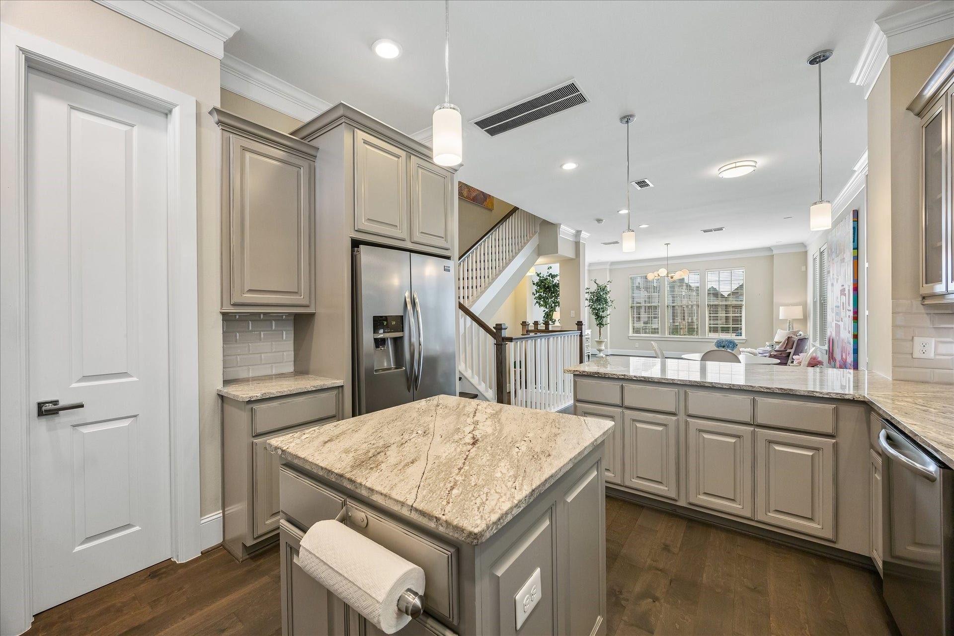 One more view of this fabulous kitchen showcasing the island, granite countertops & decorative pendant lighting! Glass-front display cabinetry, pantry & convenient pull-out trash drawer provide wonderful additional storage & organization. Open sight lines to dining & living spaces create a seamless flow throughout the 2nd floor. Truly the heart of the home!