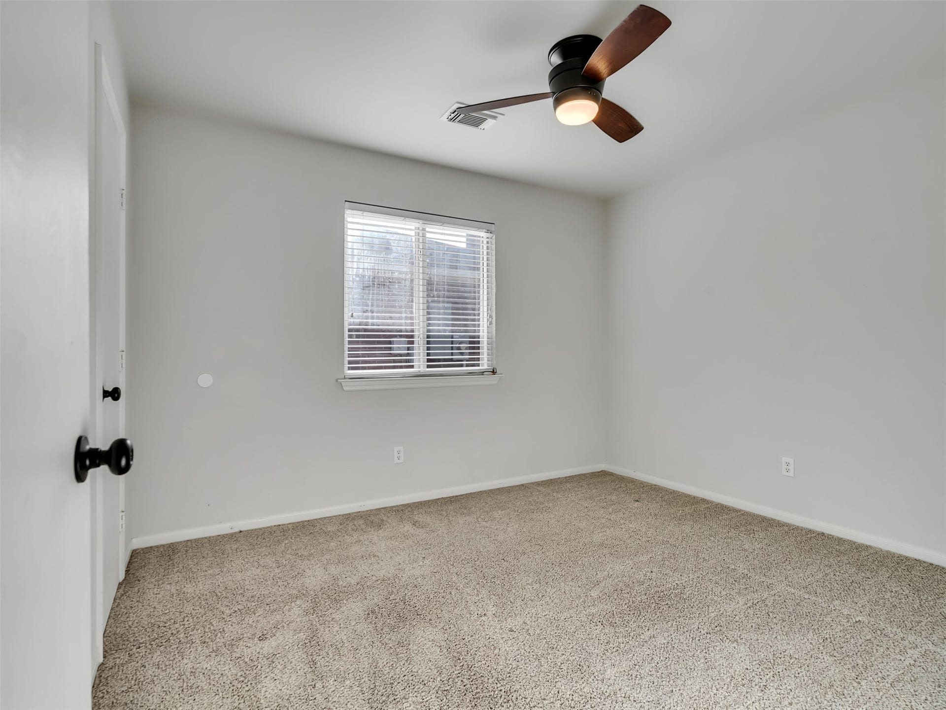 21518 Gannet Peak Way, Katy, TX 77449 A simple, unfurnished room with neutral walls, carpeted flooring, a central ceiling fan, and a window providing natural light.