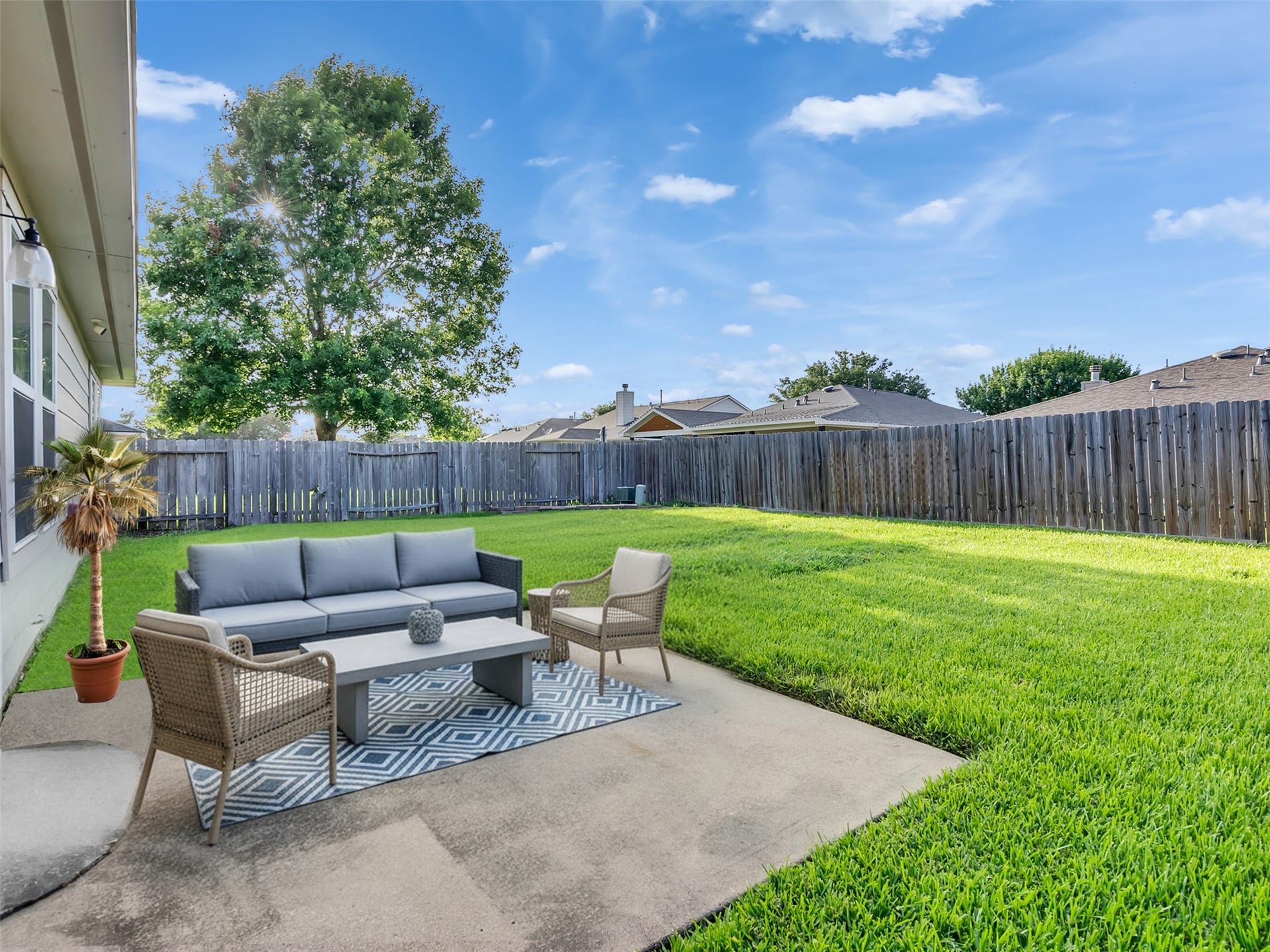 21518 Gannet Peak Way, Katy, TX 77449 Spacious backyard with a well-maintained lawn, patio seating area, and privacy fence. Ideal for outdoor relaxation and entertainment.