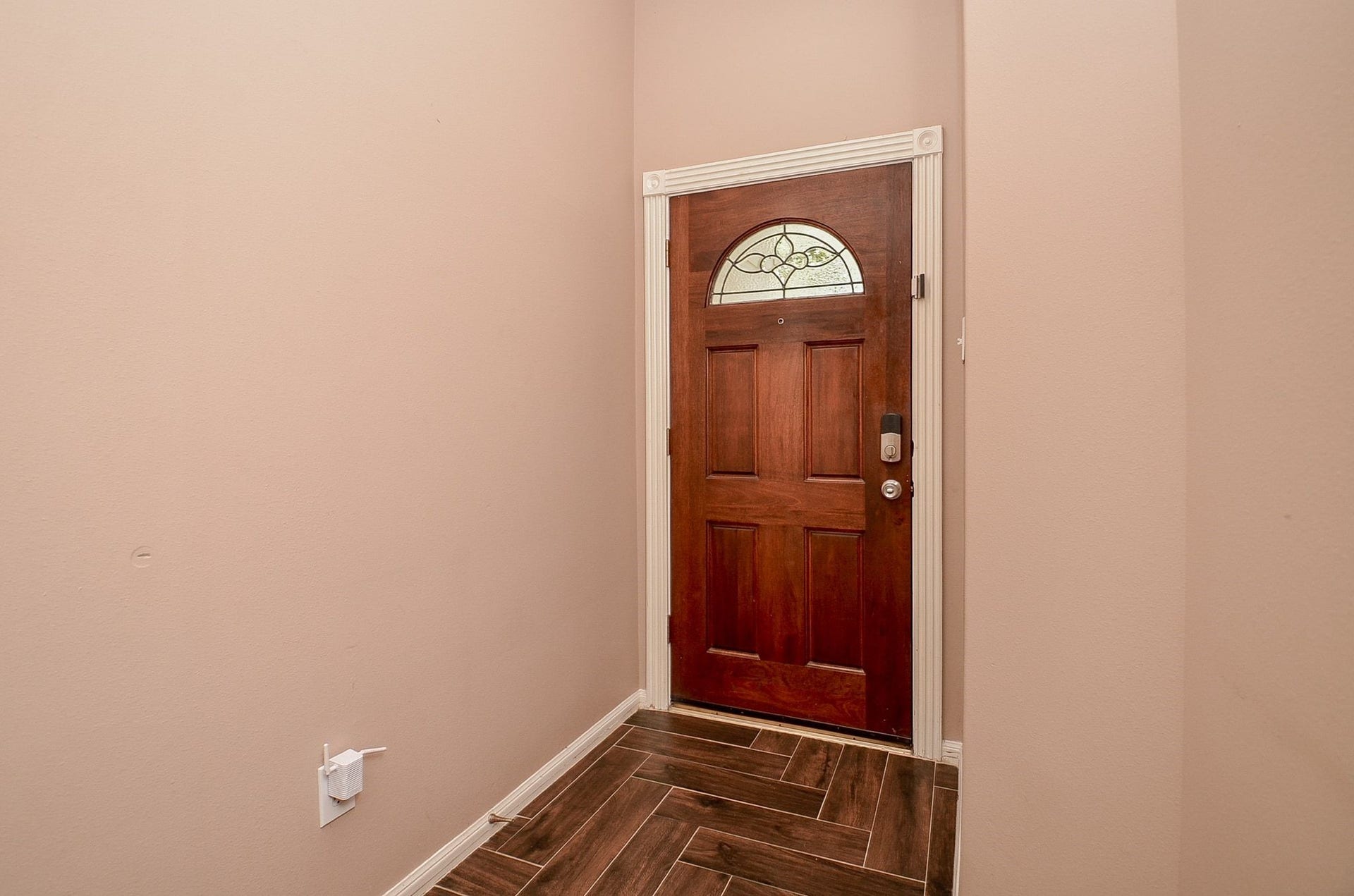 3706 Cane Lake Drive, Richmond, TX 77406 Inviting entryway with a rich wooden door featuring an elegant glass insert, complemented by warm-toned walls and stylish tile flooring.