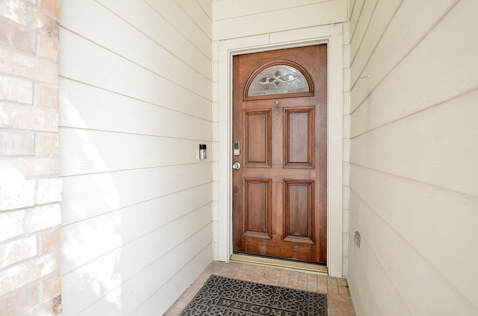 3706 Cane Lake Drive, Richmond, TX 77406 Charming wooden front door with an elegant arched window, set against a welcoming entryway with brick accents.