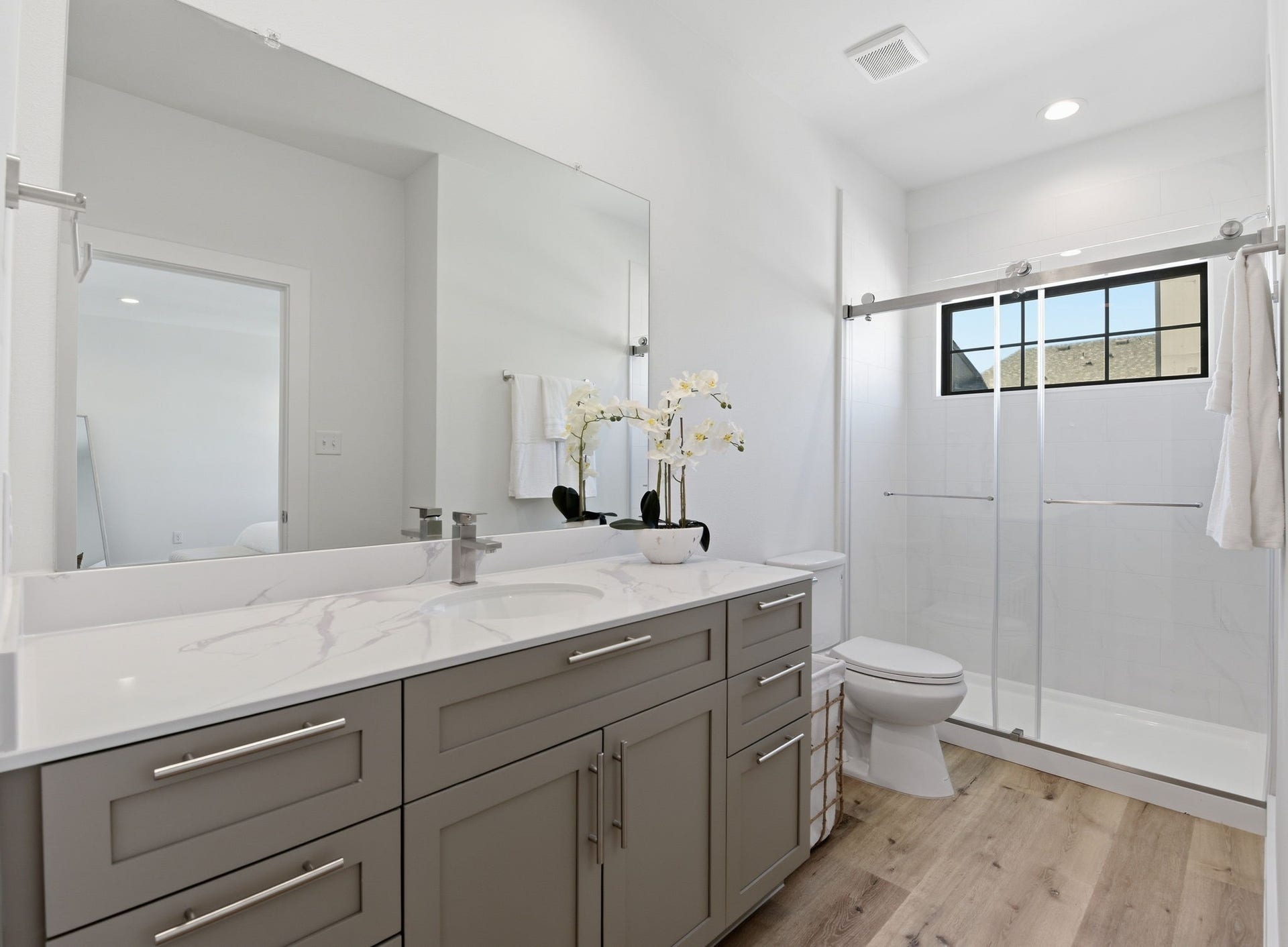 11930 S Hoa Sen Circle, Houston, TX 77072 Primary bath with walk-in shower and sliding door for convenience, bright vanity sink, and a window that brings in natural light.