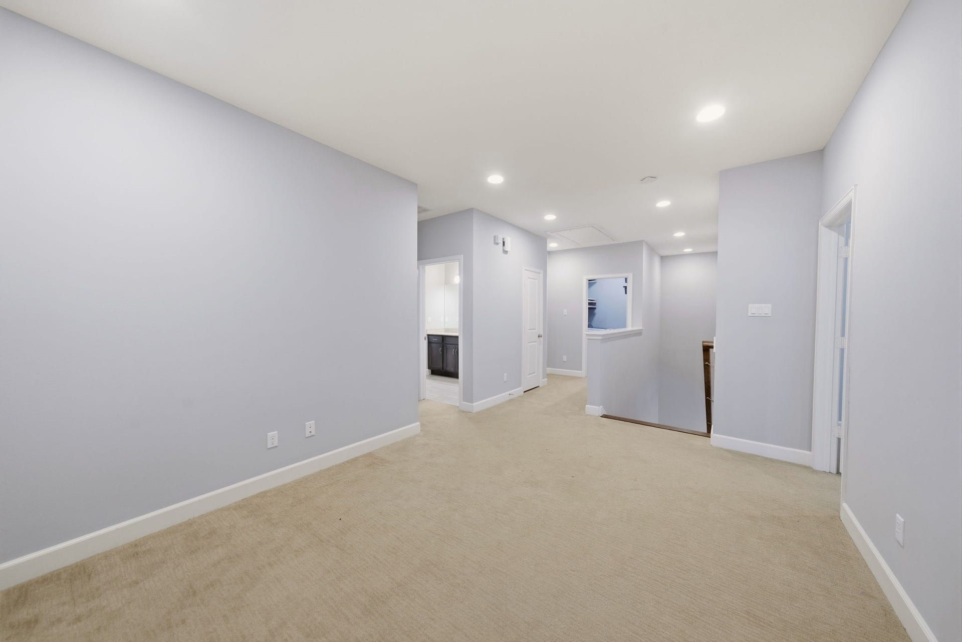 4926 Ella Boulevard, Houston, TX 77018 Flex space upstairs great for a game room, spacious, carpeted hallway with soft neutral-wall color and recessed lighting. Versatile layout suitable for various uses.