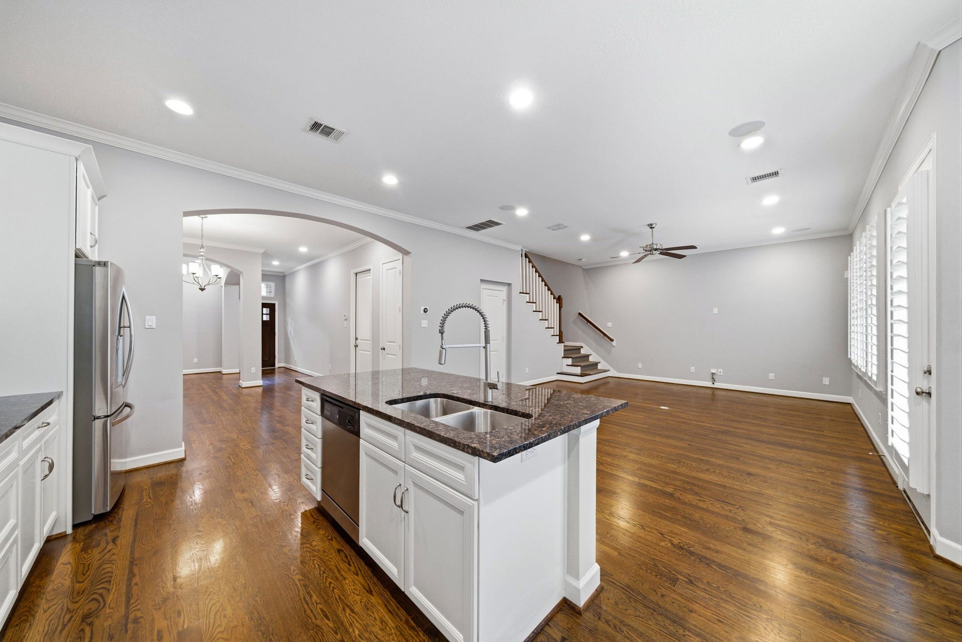 4926 Ella Boulevard, Houston, TX 77018 This open-concept living space features a modern kitchen with granite countertops and stainless steel appliances, flowing seamlessly into a spacious living area with hardwood floors, recessed lighting large windows with plantation shutters provide plenty of natural light.