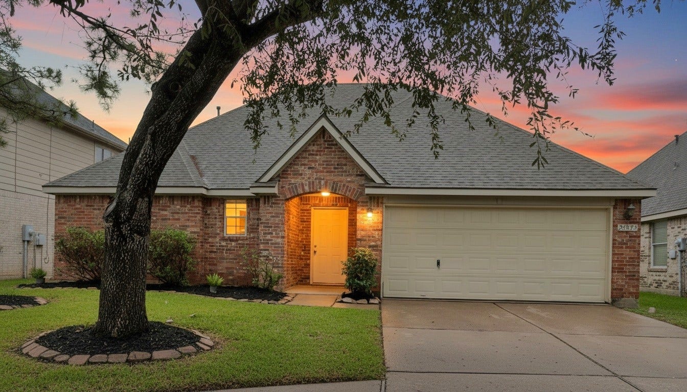 24822 Cobble Canyon Lane, Katy, TX 77494 Front exterior view of the house with attached garage and front lawn.
