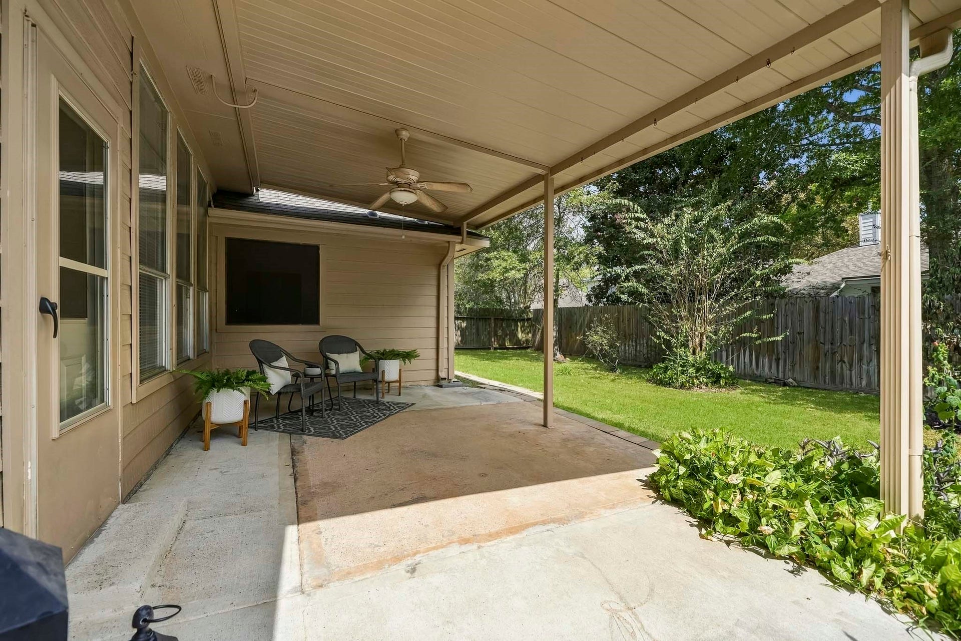 16831 Dunbar Grove Ct, Sugar Land, TX 77498 Another view of the covered patio and fenced backyard, where mature landscaping creates a pleasant setting with plenty of room for kids or pets to play.