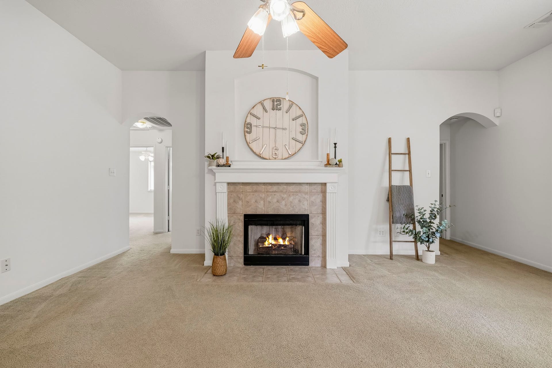 16831 Dunbar Grove Ct, Sugar Land, TX 77498 Spacious, bright and freshly painted, the family room features a fireplace with mantel and the arched entryways provide access to the secondary bedrooms (on the left) and the primary suite (on the right).