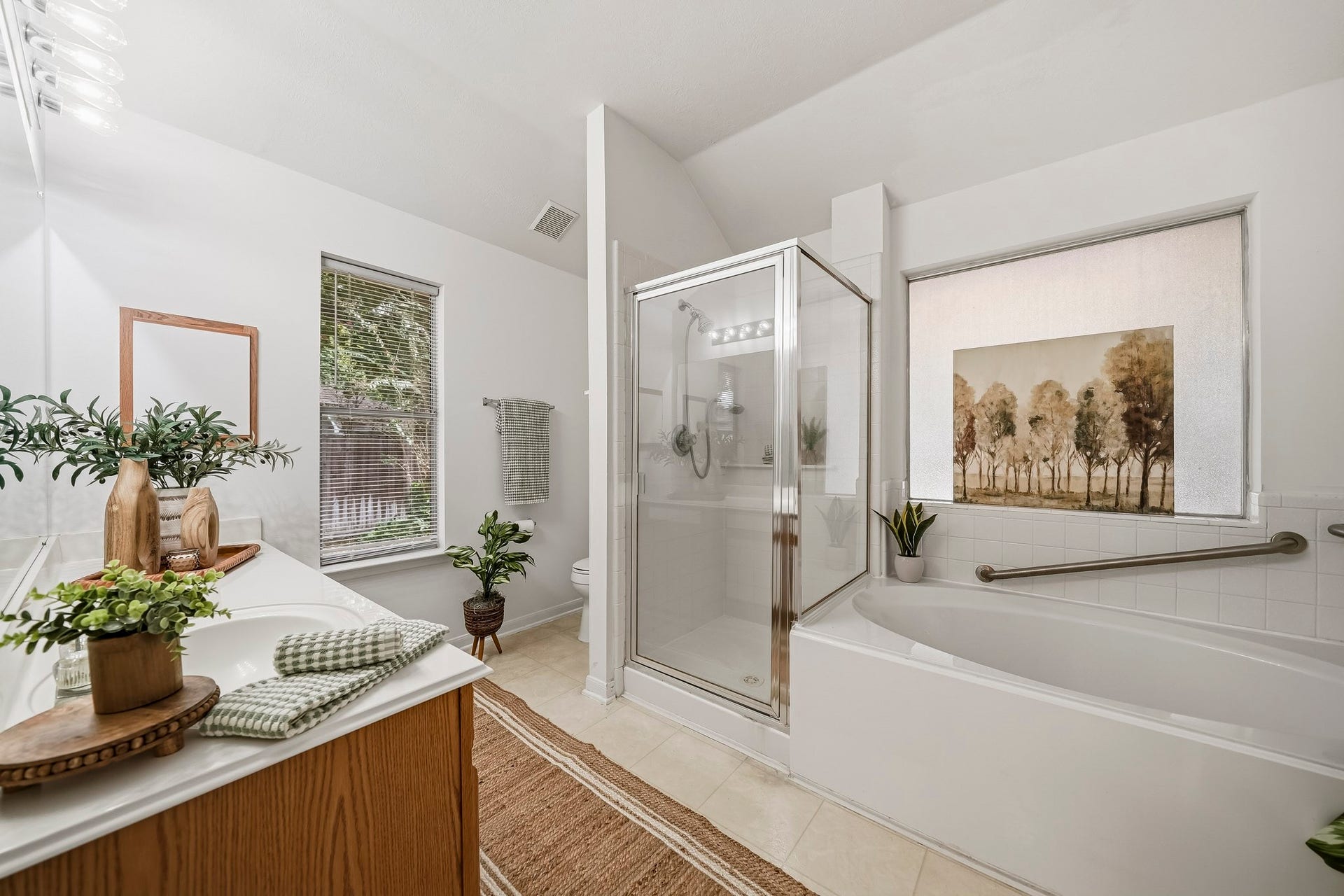 16831 Dunbar Grove Ct, Sugar Land, TX 77498 The well-appointed primary bath features two windows to bring natural light into the space, including one with privacy glass overlooking the patio area.