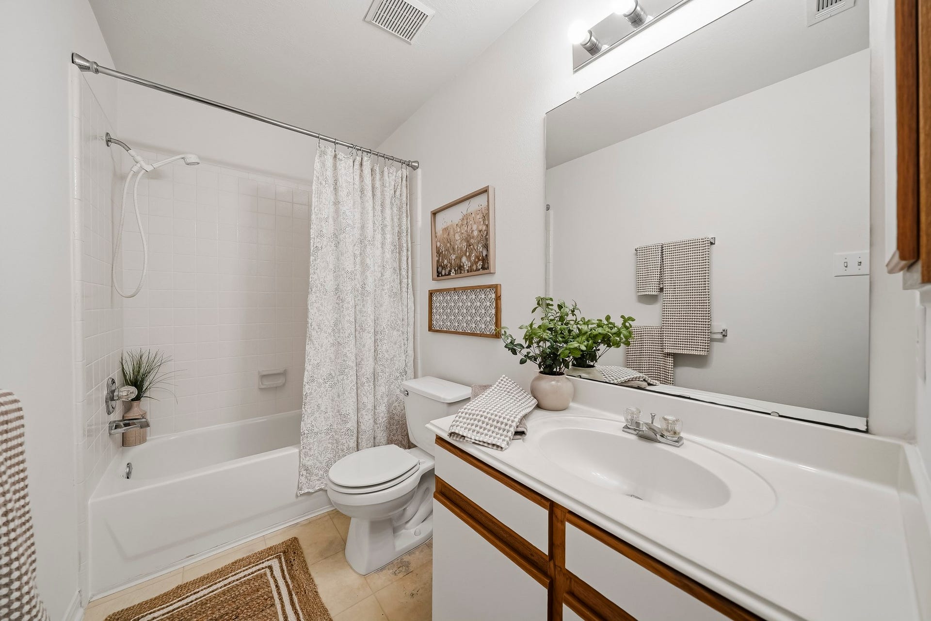 16831 Dunbar Grove Ct, Sugar Land, TX 77498 The secondary bath is conveniently located near the additional bedrooms and features a tub/shower combination with white tile, vanity storage and a medicine cabinet.
