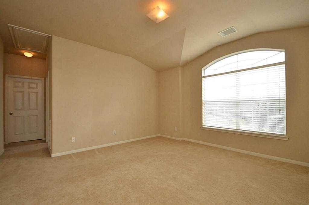 2502 Quiet Sage Lane, Katy, TX 77494 This bedroom features cozy carpeting and a large window that floods the space with natural light.