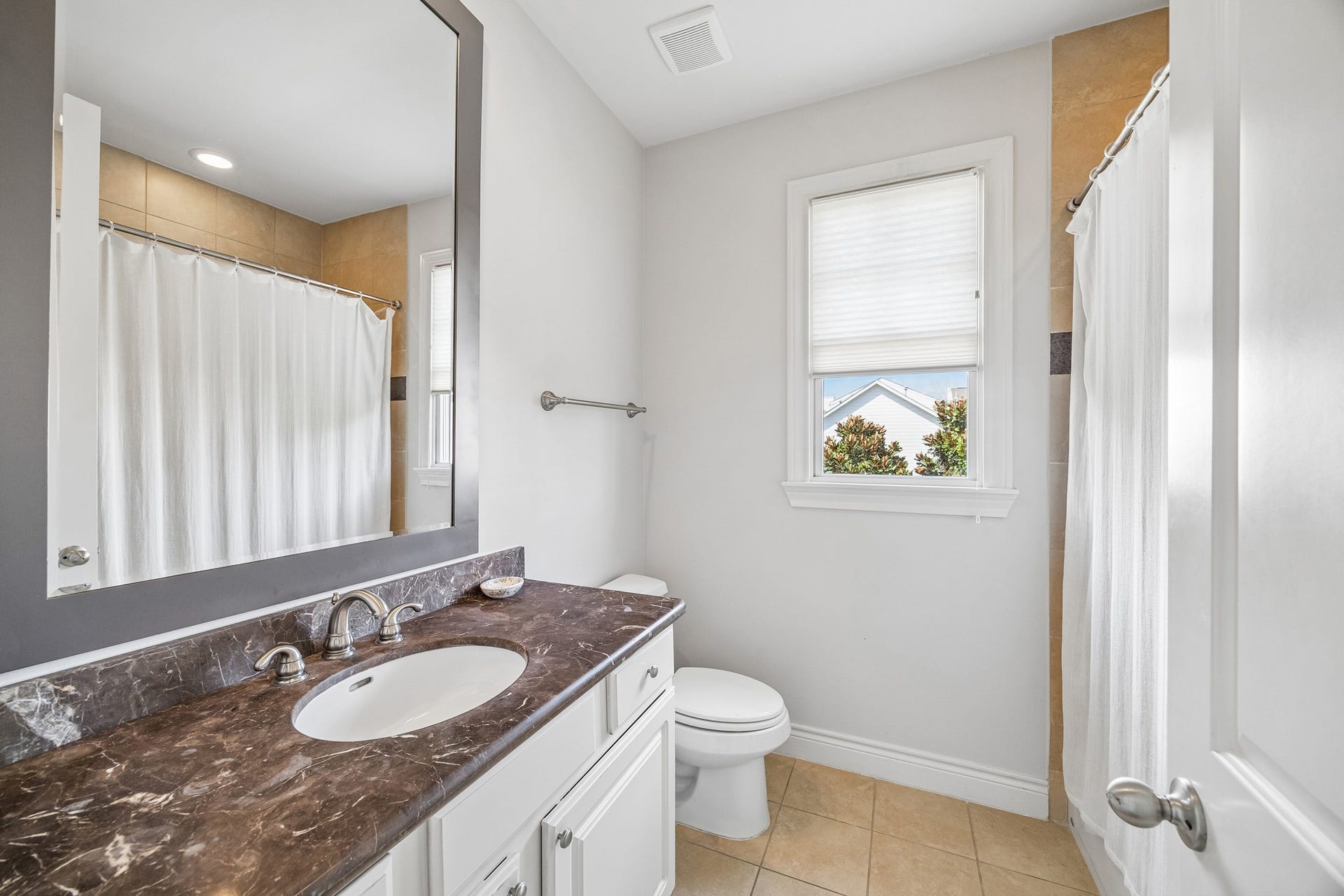Secondary 3rd floor hallway bathroom with sleek marble countertop, window, tub / shower combo, and ceramic tile flooring.
