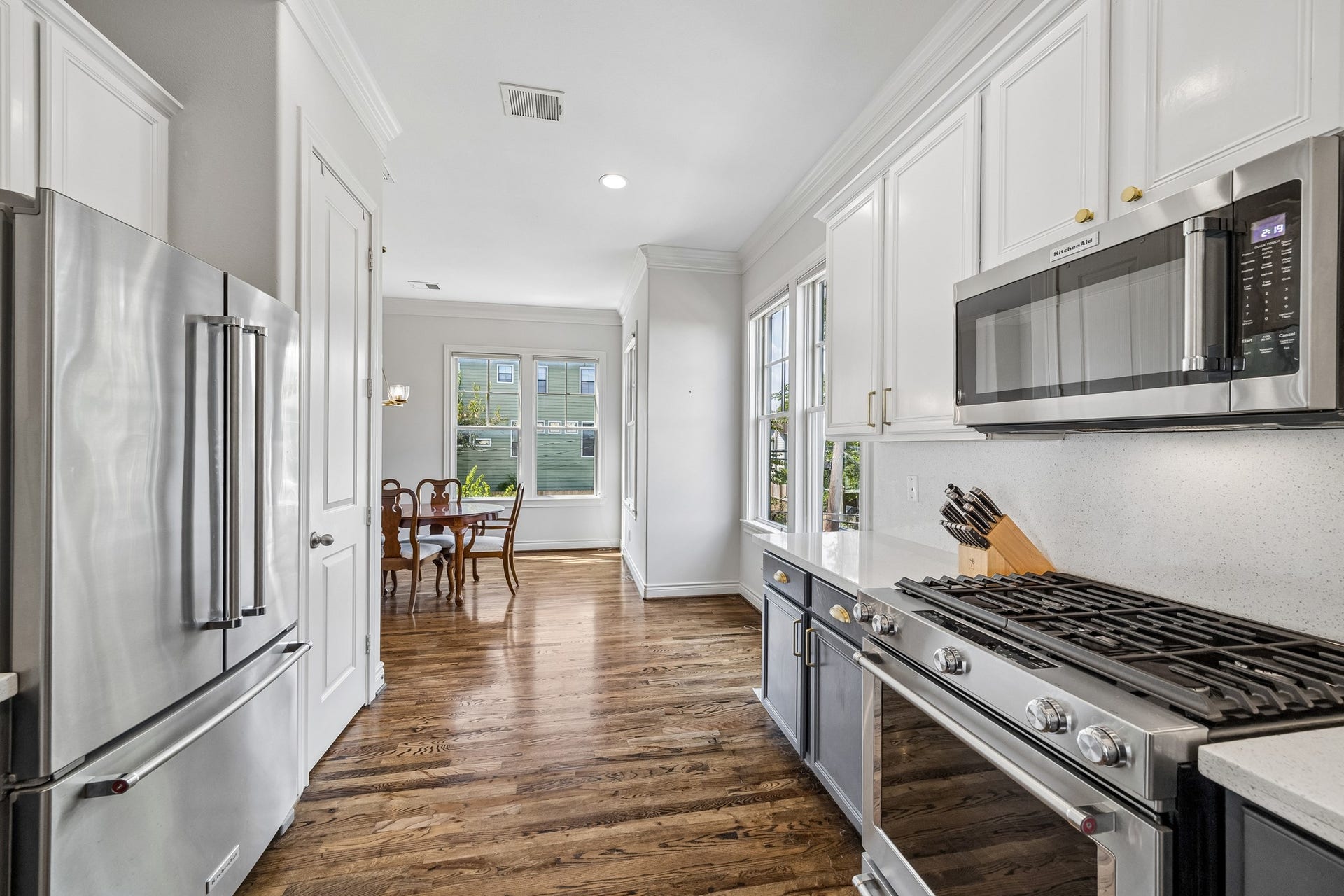 Note how spacious and easy to navigate the kitchen is while flowing into a dedicated dining area. Windows wash the space with natural light.