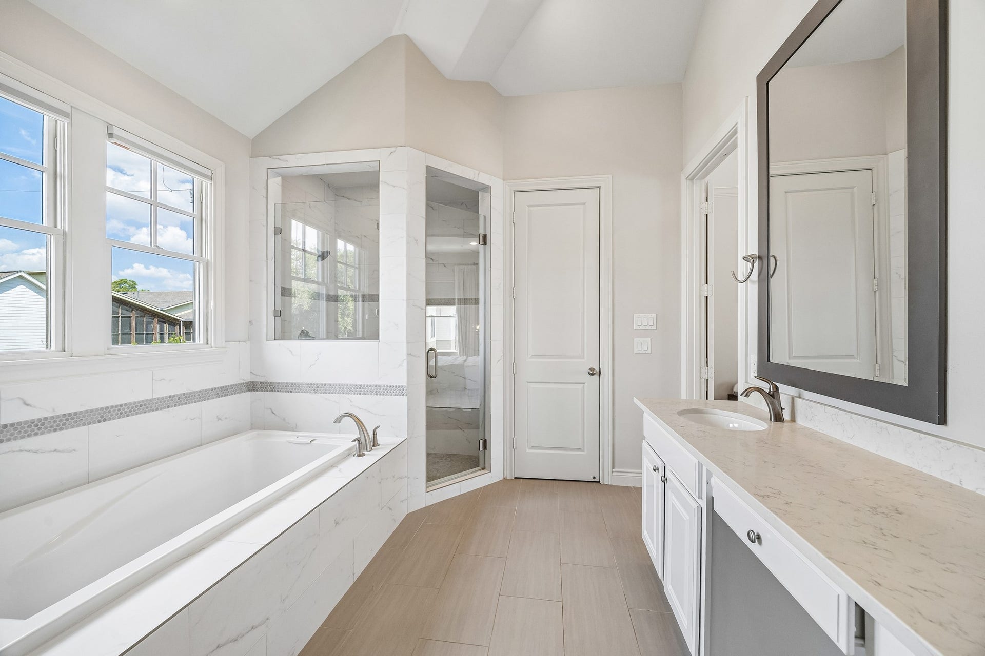Another view of the 3rd floor primary ensuite bathroom showcasing the spacious glass-enclosed shower and door leading to private water closet. The entrance to the bedroom is the door to the right.