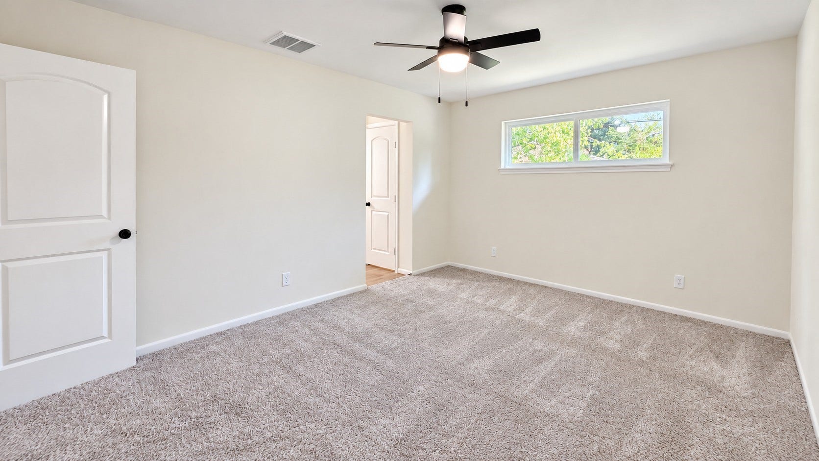 5527 Wigton Drive, Houston, TX 77096 Primary bedroom offers a generous footprint, ceiling fan, soft carpeting, and natural light.