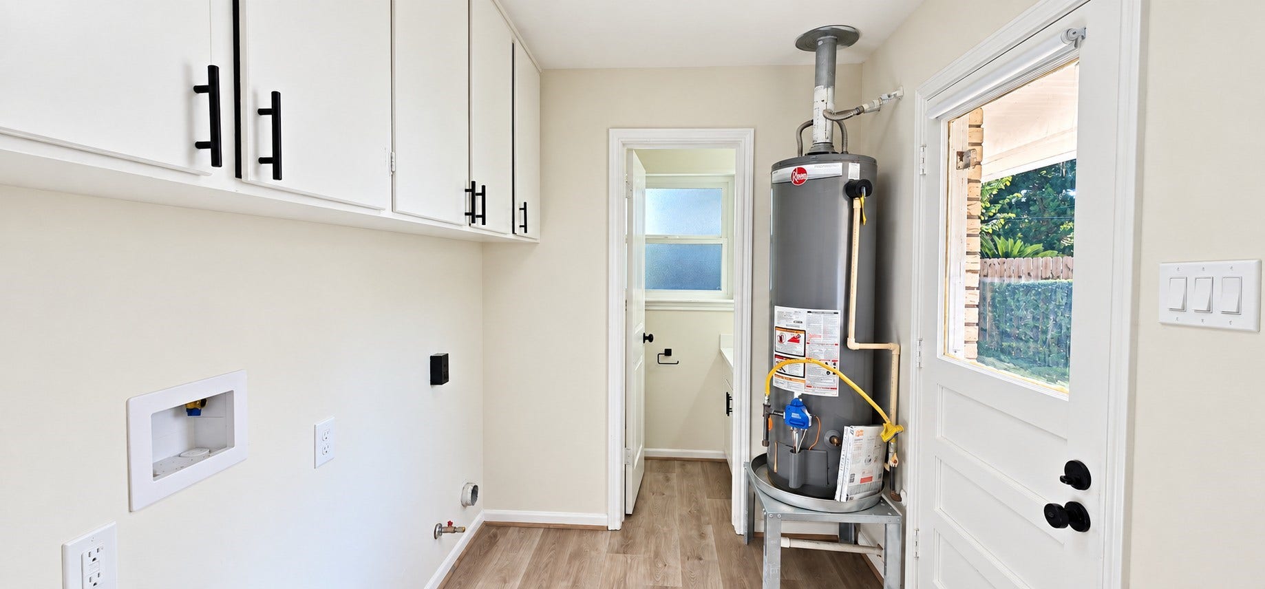5527 Wigton Drive, Houston, TX 77096 Dedicated laundry room offers built-in upper cabinetry, washer/dryer connections, and convenient backyard access.