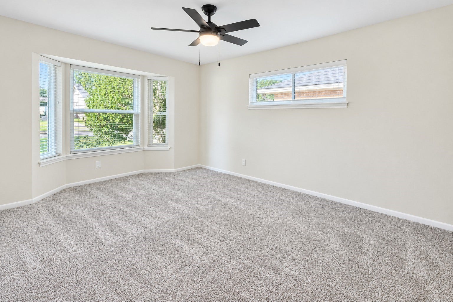 5527 Wigton Drive, Houston, TX 77096 Secondary bedroom with ceiling fan, plush carpet, and multiple windows providing abundant natural light.