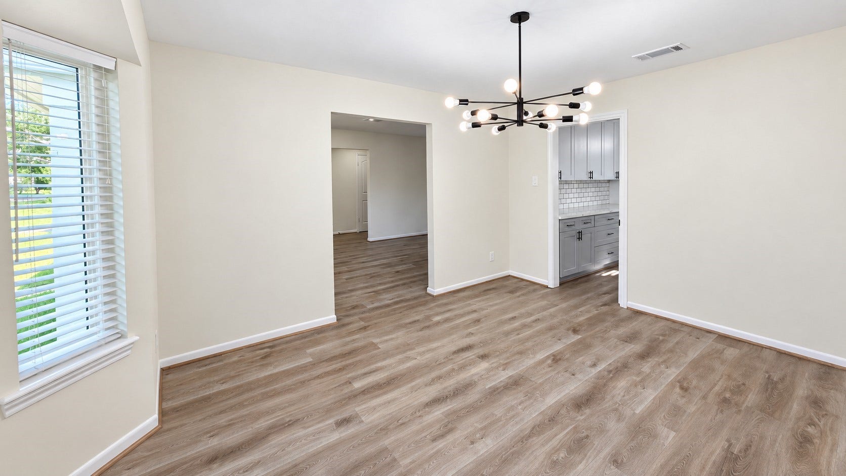 5527 Wigton Drive, Houston, TX 77096 Dedicated dining room with contemporary statement lighting and abundant natural light from the bay windows.