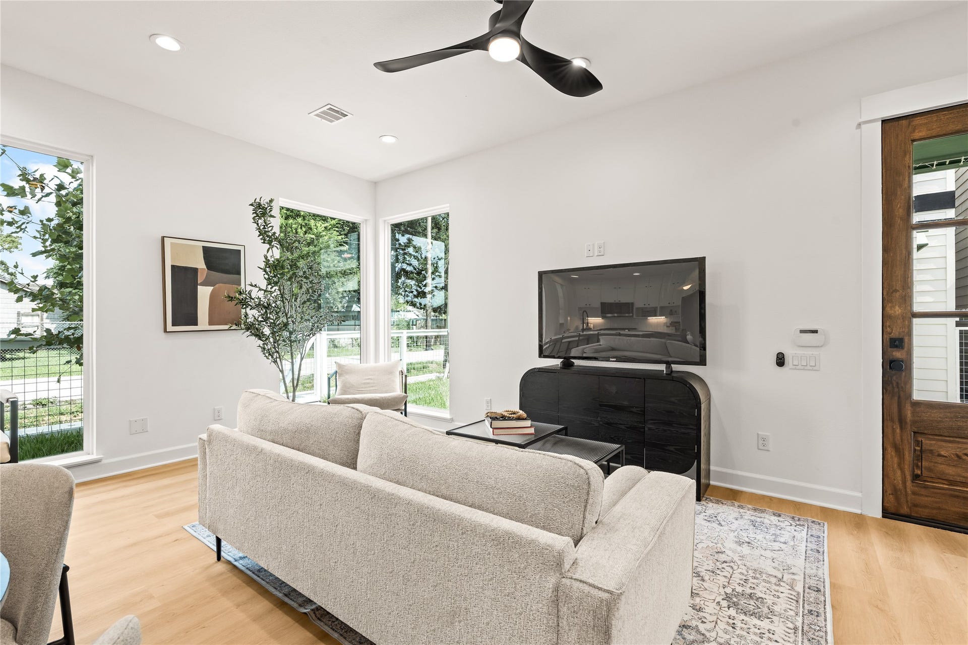 7432-7444 Tremper Street, Houston, TX 77020 Main living volume open plan, ceiling fan, natural light drawn through floor-to-ceiling glazing