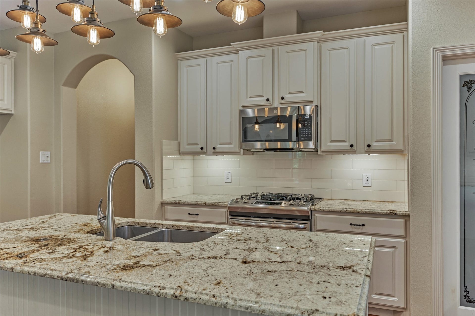 1794 Canyon Lake Creek Drive, Conroe, TX 77304 Under counter lighting, granite countertops with decorative edge and subway tile backsplash are a few designer features of this bright kitchen.