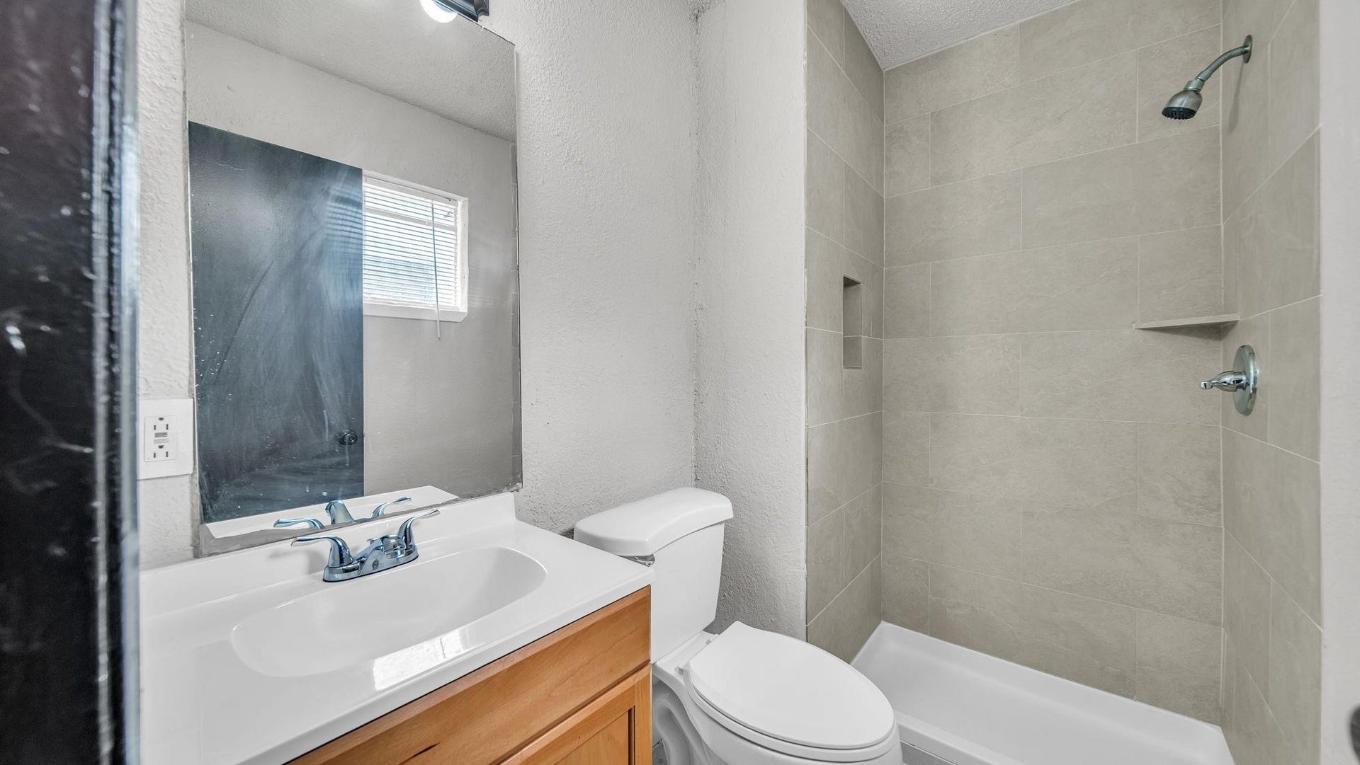 10902 Jutland Road, Houston, TX 77048 The en suite bath offers an elegant combination of style and functionality, featuring a beautifully appointed shower with 12 x 24 tile extending to the ceiling, a built-in shampoo niche, and a cultured marble vanity. Sophisticated finishes create a polished, inviting space for daily routines.