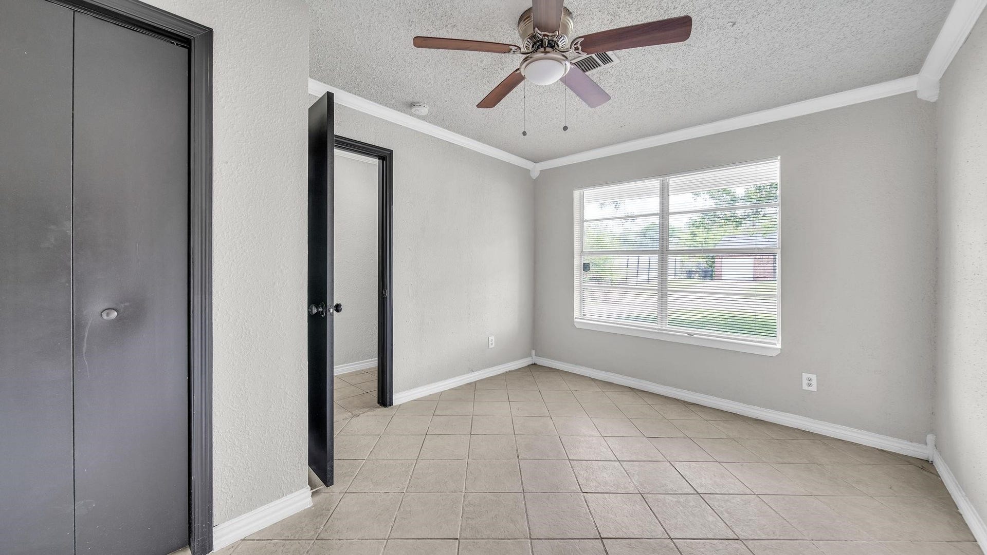 10902 Jutland Road, Houston, TX 77048 The third bedroom offers a bright, welcoming atmosphere, with two windows overlooking the front yard and inviting an abundance of natural light. Tile flooring, a ceiling fan with integrated lighting, and dual closets provide an appealing combination of comfort, style and generous storage.