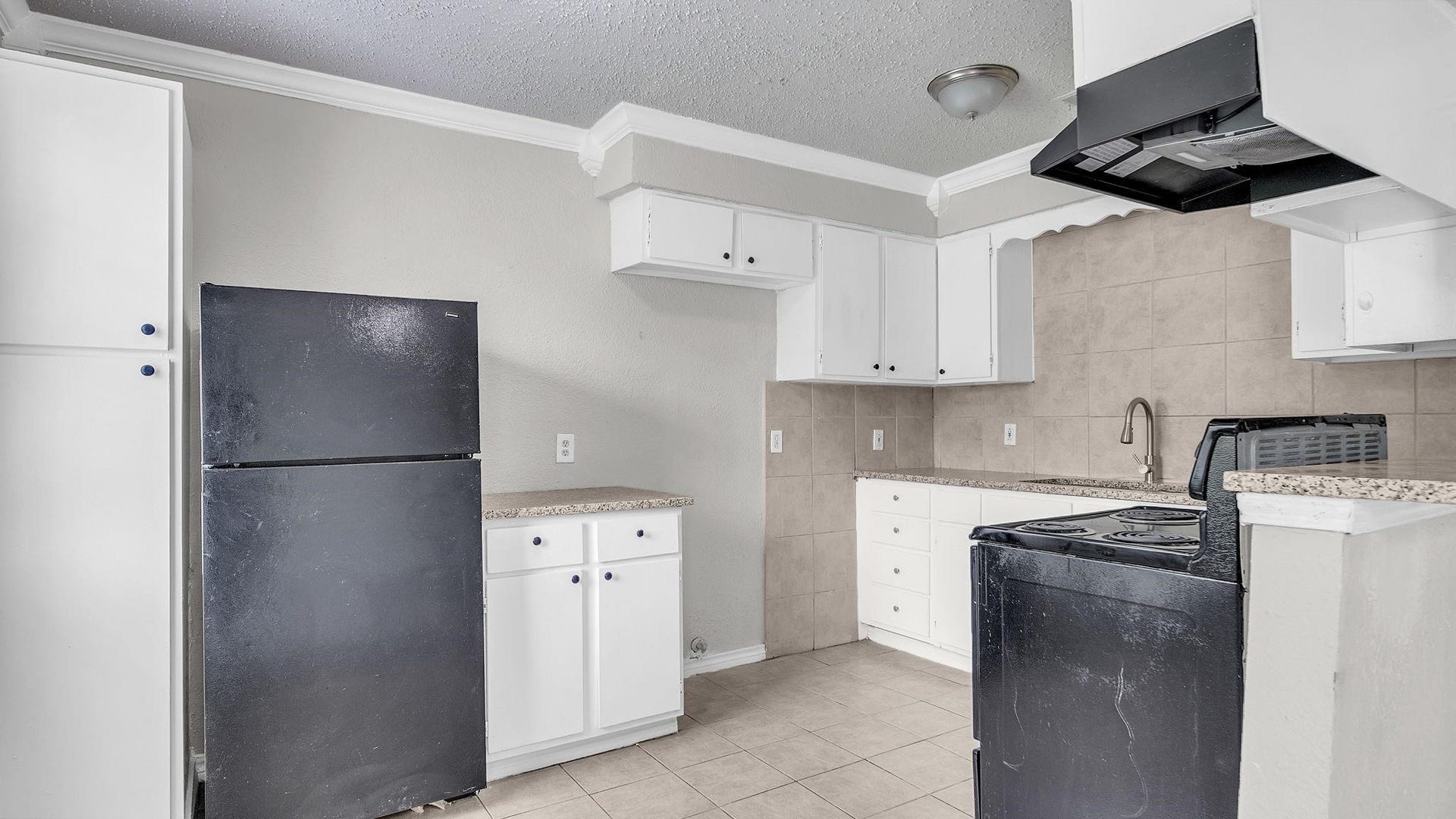 10902 Jutland Road, Houston, TX 77048 The kitchen combines style and functionality with a four-burner electric range, stainless steel double-basin sink and cabinetry featuring soft-close drawers. A refrigerator, included with the home, completes this beautifully appointed space.