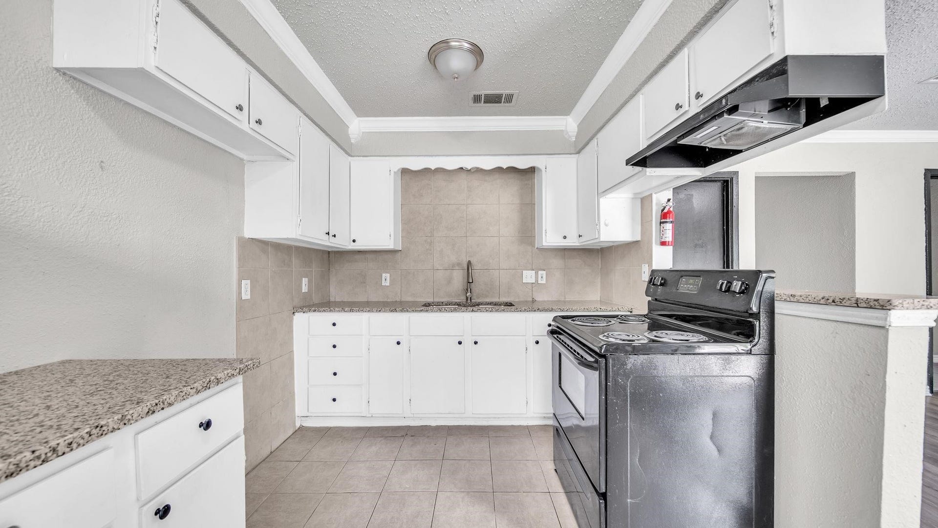 10902 Jutland Road, Houston, TX 77048 The kitchen pairs elegant granite countertops with a spacious breakfast bar, creating an inviting setting for casual dining and conversation. Tile flooring complements the space, offering timeless appeal and everyday practicality.