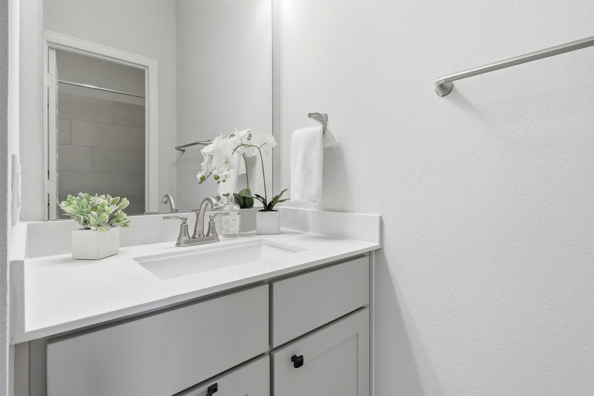 30135 Gold Finch Place, Fulshear, TX 77441 The upstairs jack-and-jill bathroom features a stylish quartz vanity with shaker-style cabinetry, designer fixtures, and generous counter space complements the upstairs bathroom, offering both beauty and everyday functionality.