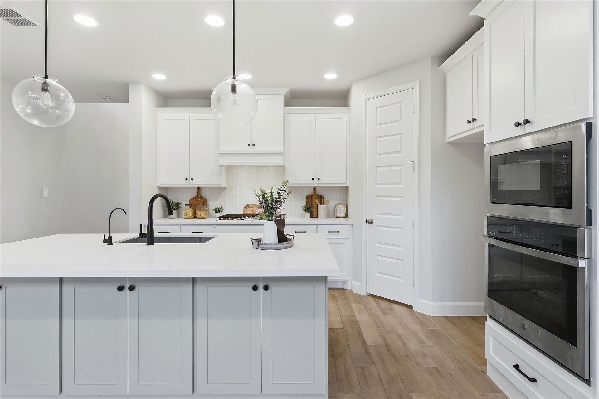 30135 Gold Finch Place, Fulshear, TX 77441 A large center island anchors the kitchen, providing ample workspace, additional storage, and casual seating. Built-in stainless steel wall ovens, expansive cabinetry, and clean architectural lines deliver both elegance and exceptional functionality.