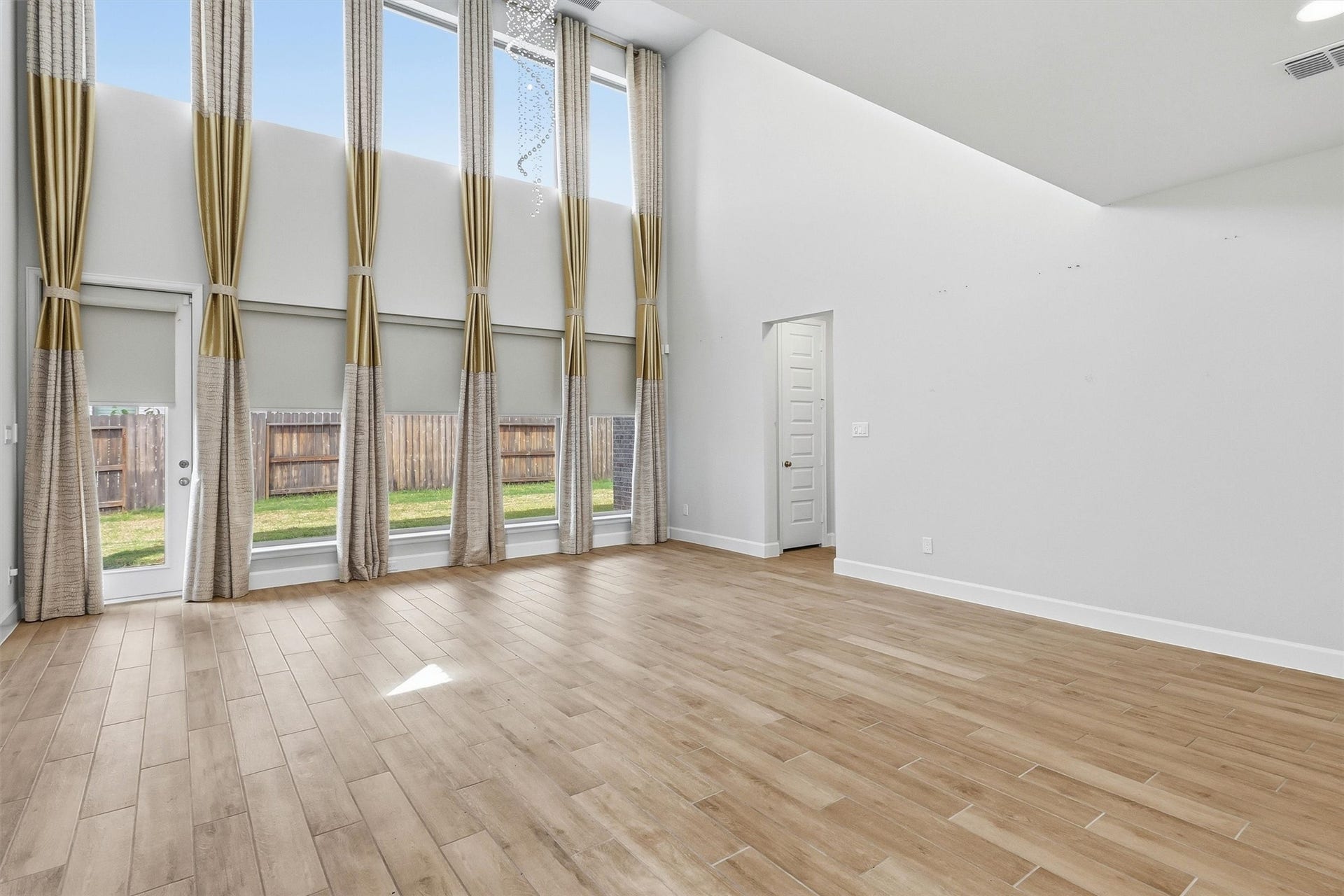 30135 Gold Finch Place, Fulshear, TX 77441 Floor-to-ceiling windows frame the backyard while filling the family room with sunlight throughout the day. The impressive ceiling height and open design create an airy, welcoming atmosphere that truly serves as the centerpiece of the home.