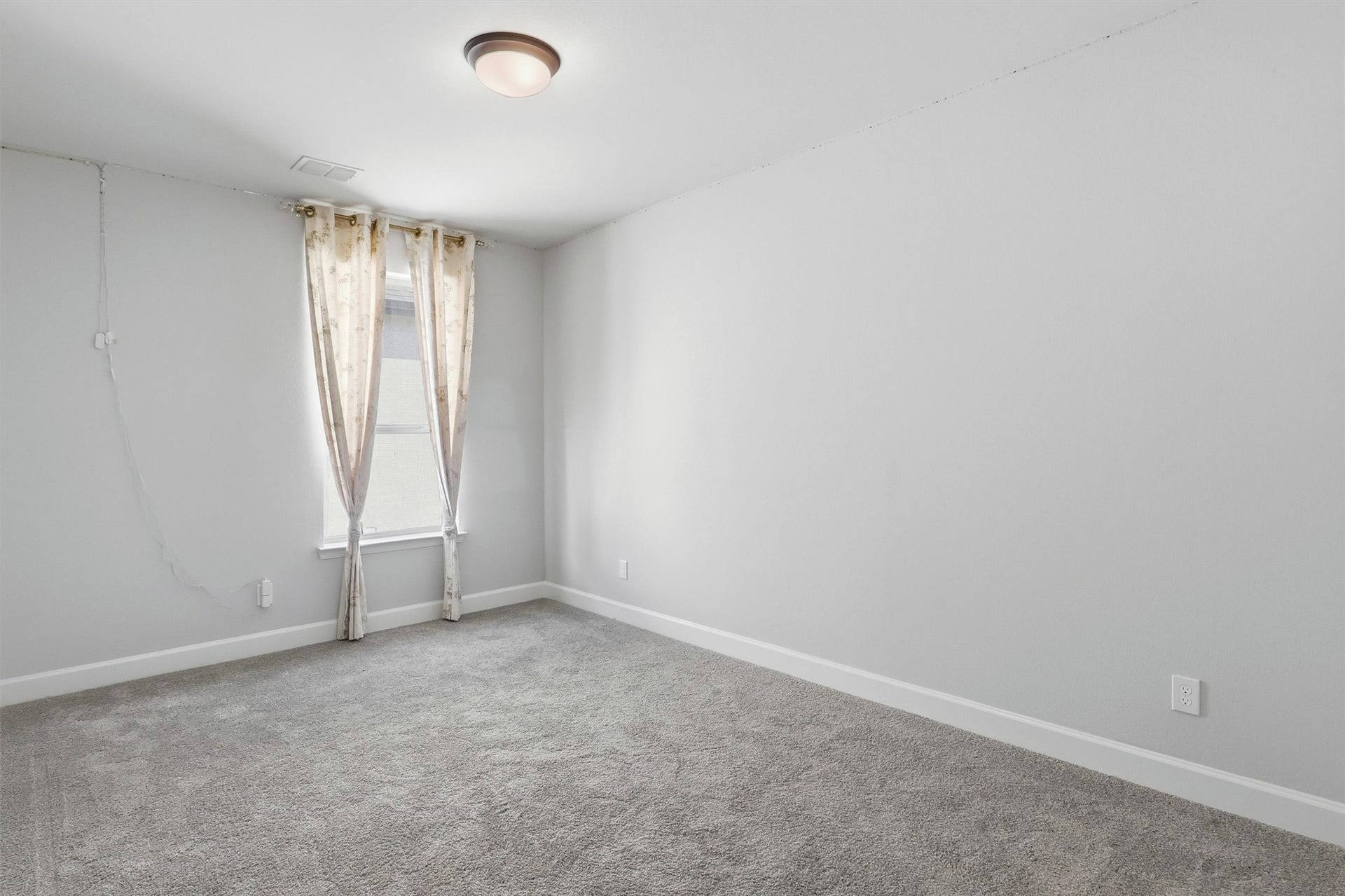 30135 Gold Finch Place, Fulshear, TX 77441 Another spacious secondary bedroom features plush carpeting, neutral finishes, and a large window that fills the room with natural light, creating a comfortable space for family or overnight guests.