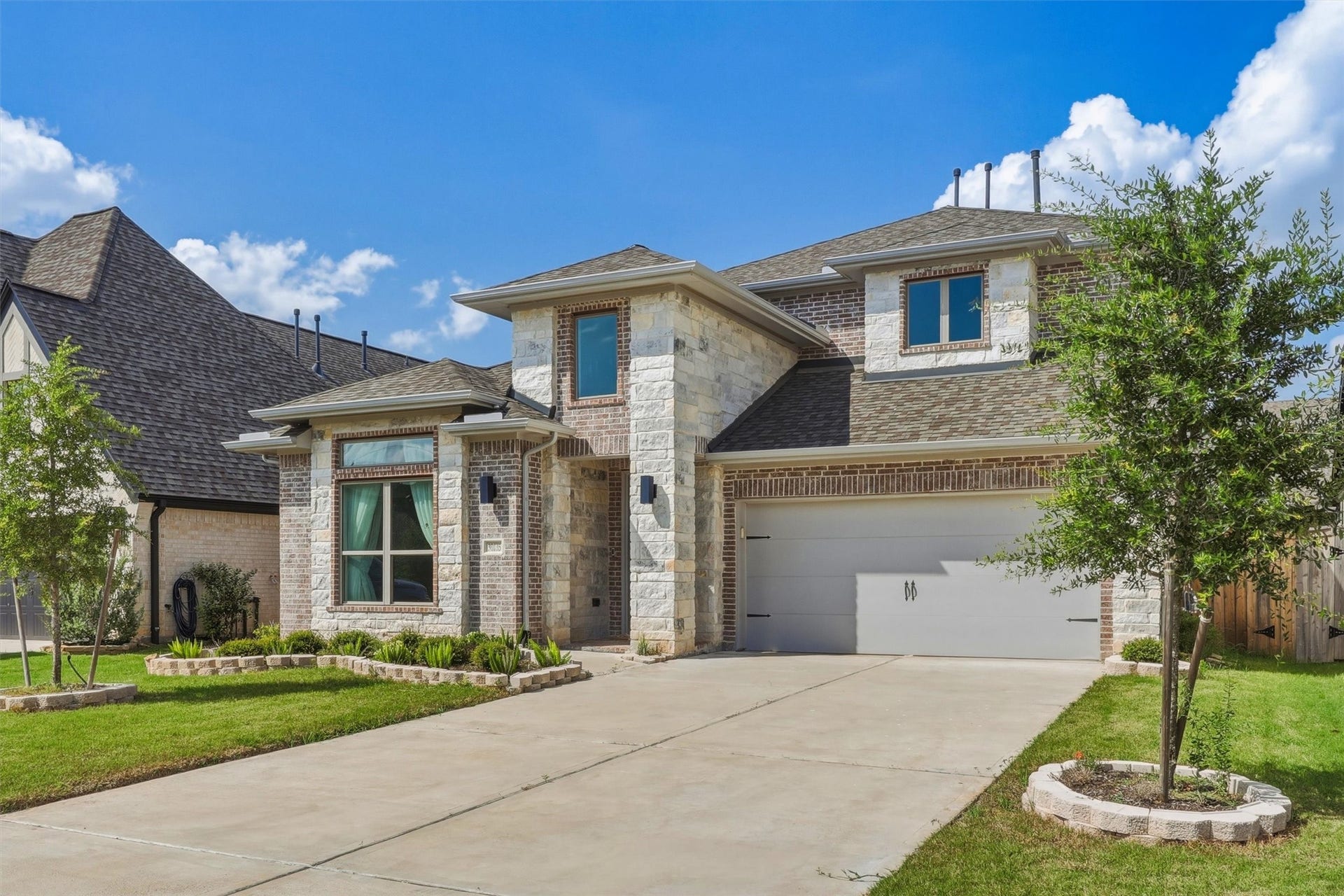 30135 Gold Finch Place, Fulshear, TX 77441 This elegant two-story exterior features a sophisticated brick-and-stone faade, covered front entry, professionally maintained landscaping, and an attached two-car garage. Thoughtfully designed architecture delivers exceptional curb appeal from every angle.