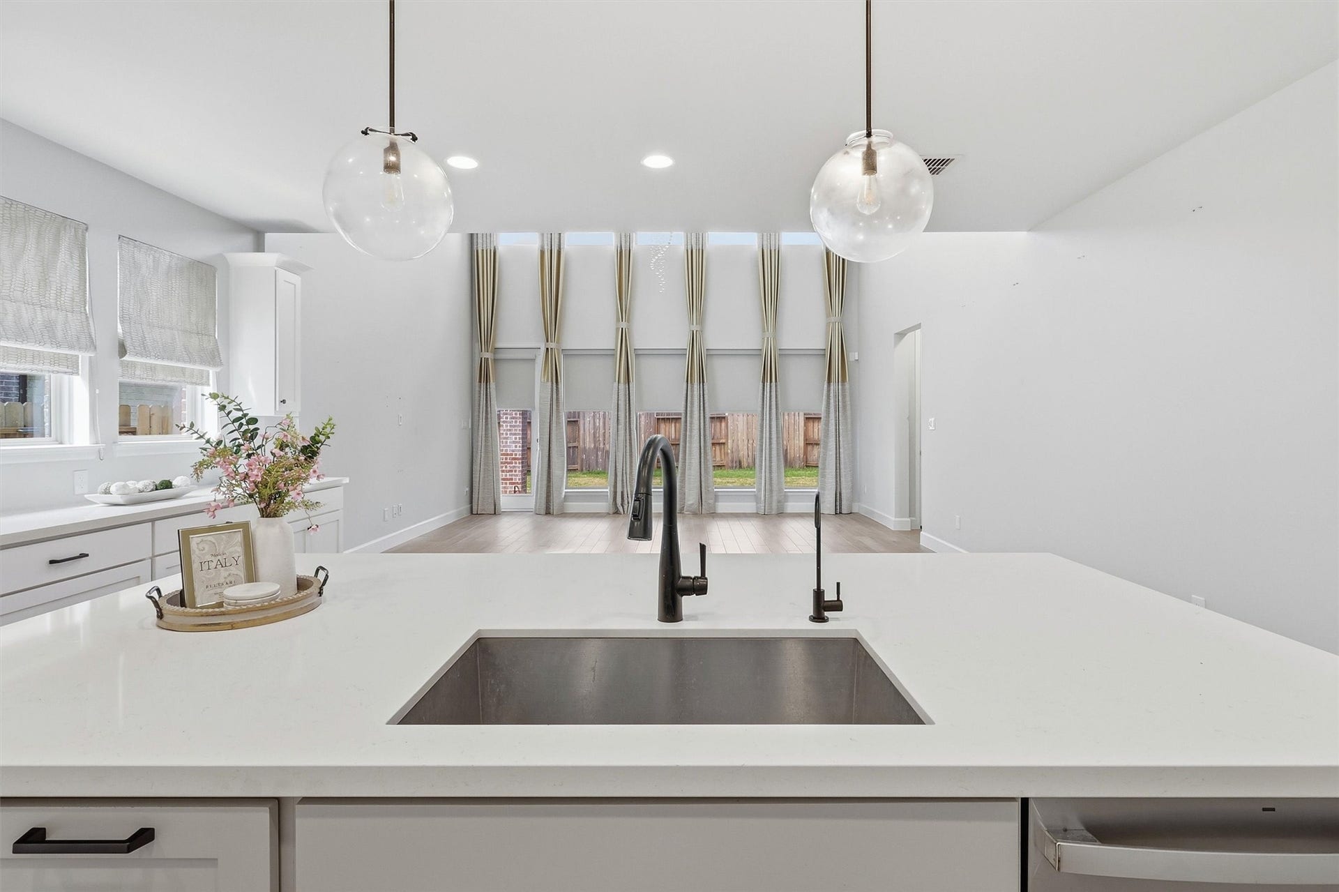 30135 Gold Finch Place, Fulshear, TX 77441 From the kitchen sink, enjoy uninterrupted views of the impressive two-story family room and backyard beyond. The oversized island creates the perfect gathering place while maintaining an open flow ideal for entertaining family and guests.