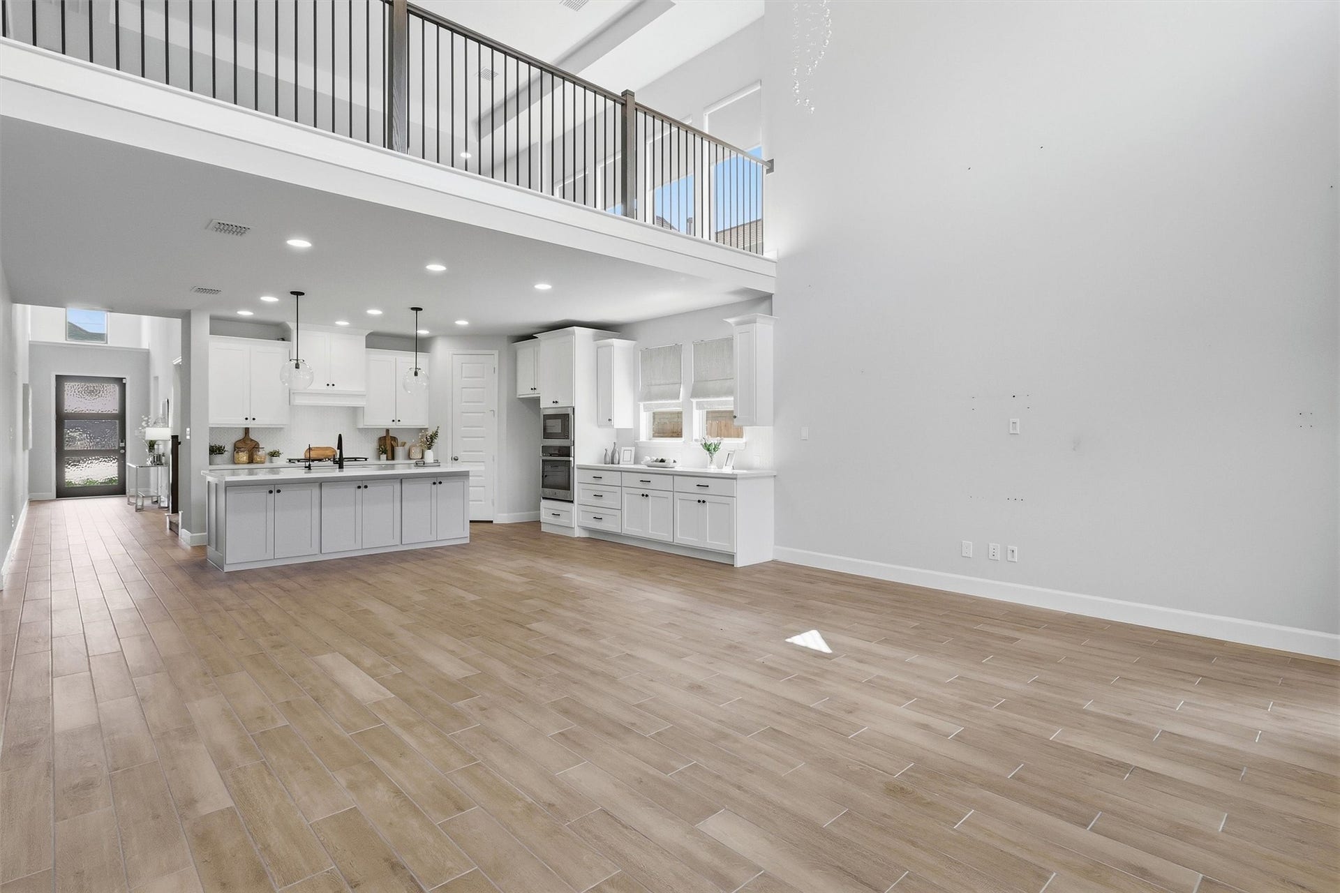 30135 Gold Finch Place, Fulshear, TX 77441 This wide-angle view captures the seamless flow between the family room and gourmet kitchen, highlighting the home's open-concept design, soaring ceilings, and exceptional sense of space that make entertaining effortless.