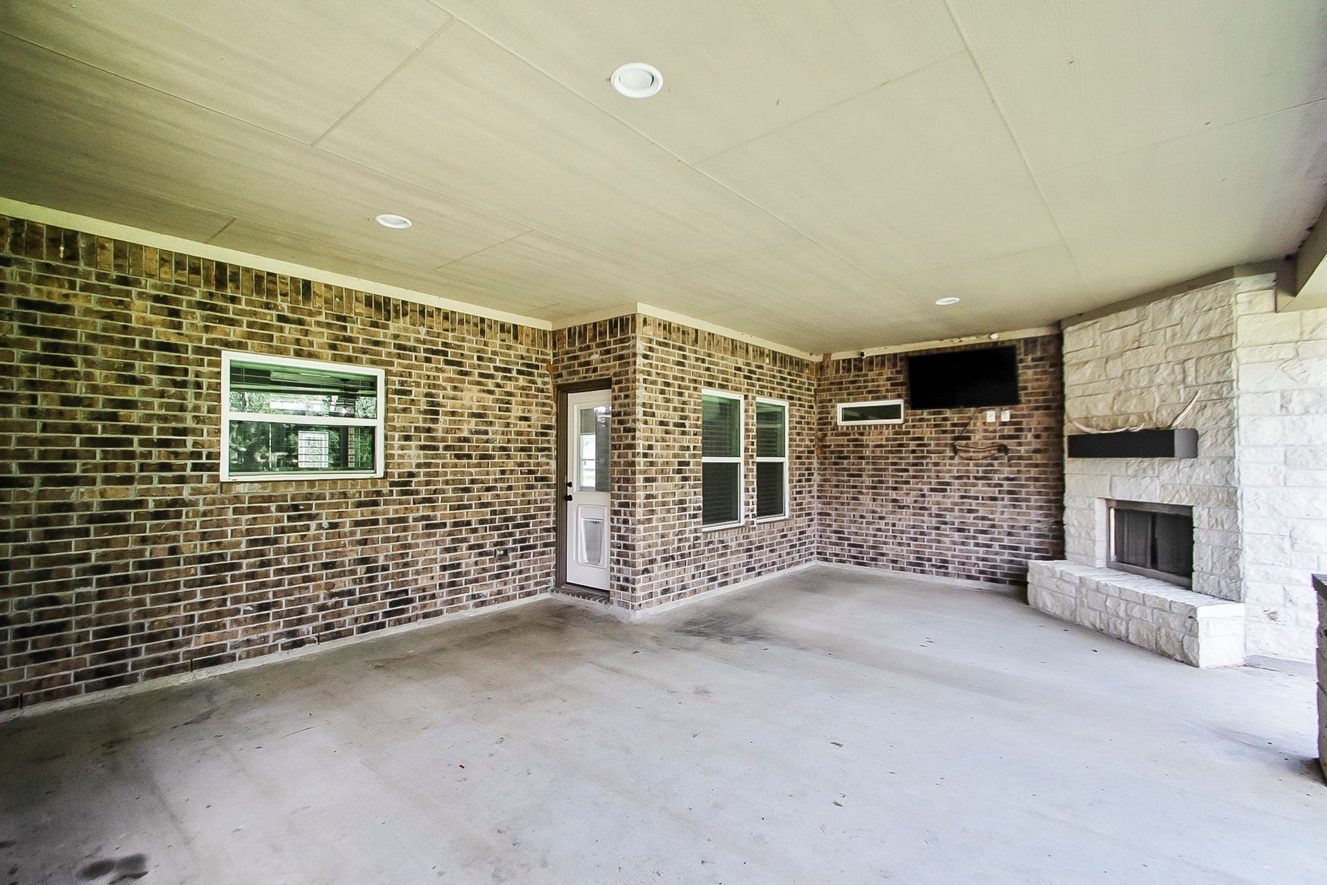 Massive covered back patio with beautiful stone fireplace