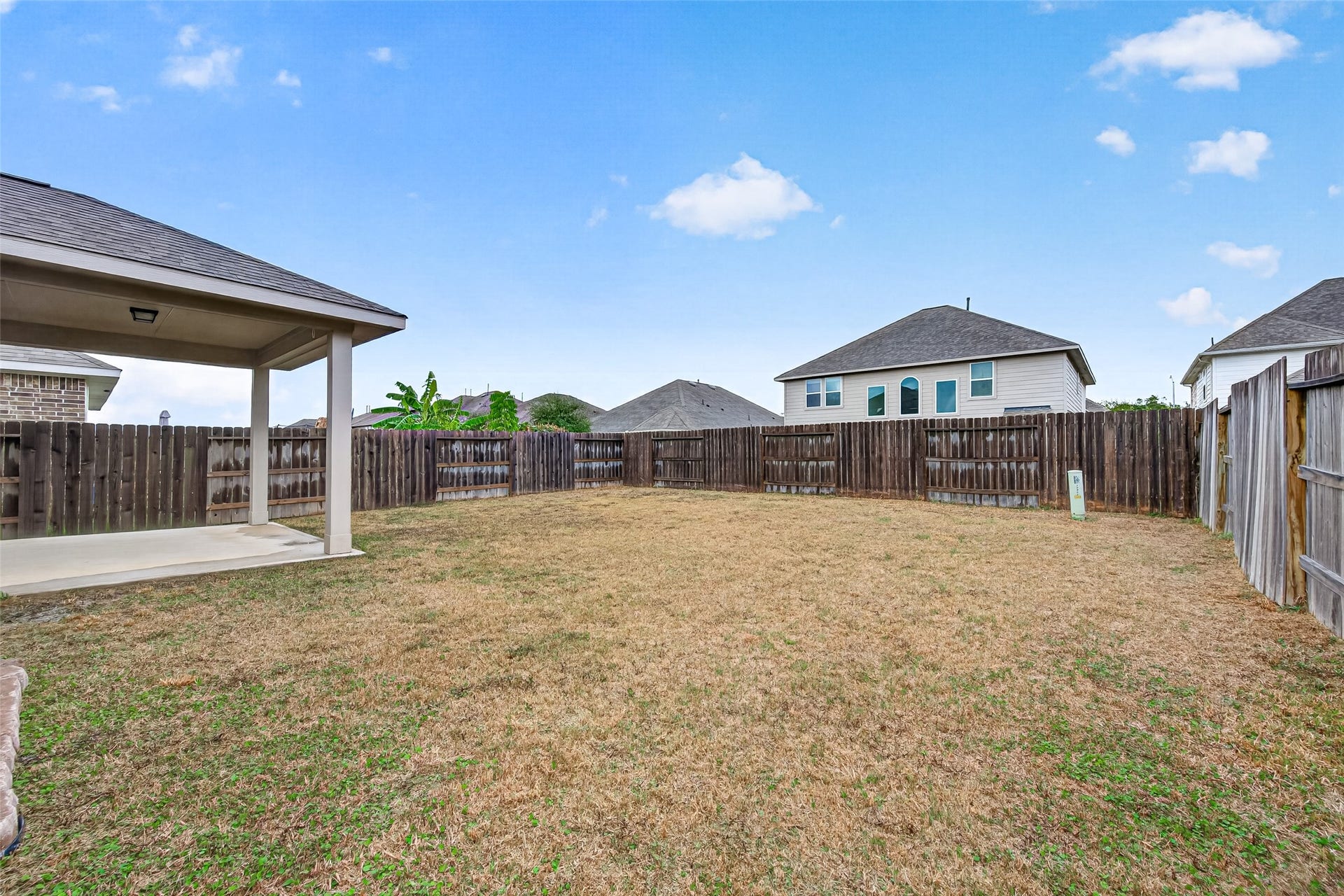 32922 Ruthie Dean Drive, Fulshear, TX 77423 An additional backyard view shows the open lawn and its connection to the covered patio.