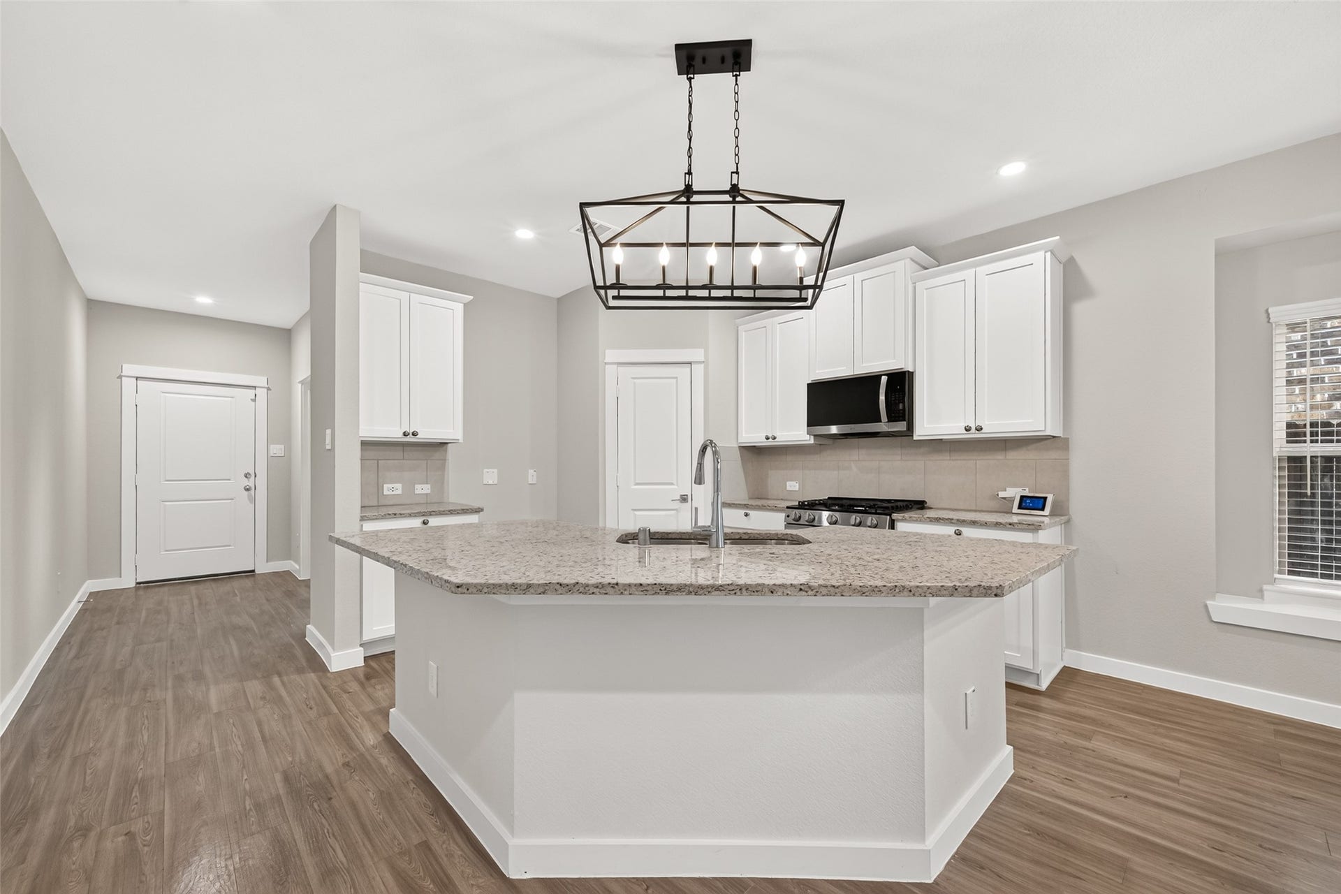 32922 Ruthie Dean Drive, Fulshear, TX 77423 Breakfast-bar seating provides a casual gathering spot, while upgraded lighting adds character above the kitchen counter.