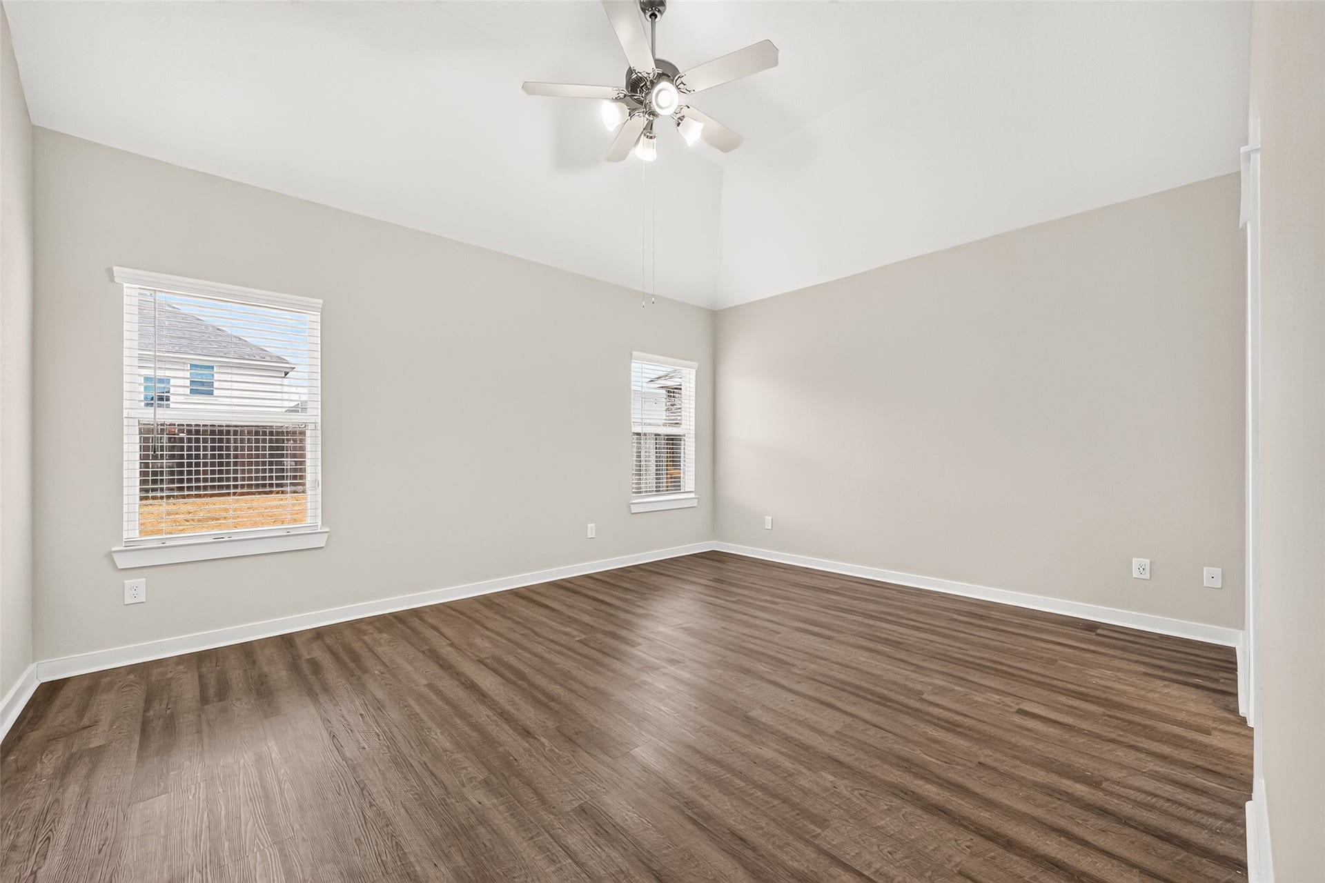 32922 Ruthie Dean Drive, Fulshear, TX 77423 Located downstairs, the primary bedroom offers a comfortable retreat with a ceiling fan and wood-look flooring.