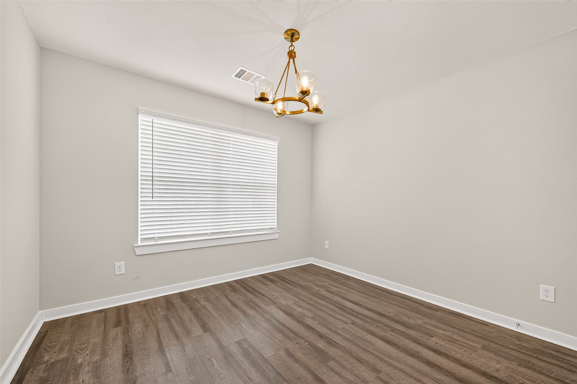 32922 Ruthie Dean Drive, Fulshear, TX 77423 Another secondary bedroom features decorative lighting, neutral walls, and wood-look flooring.
