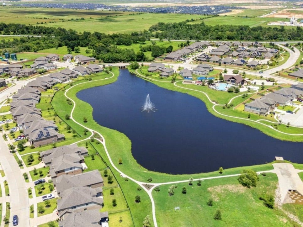 32922 Ruthie Dean Drive, Fulshear, TX 77423 An aerial view highlights the lake and surrounding Vanbrooke neighborhood. Community photonot a view from the subject property.
