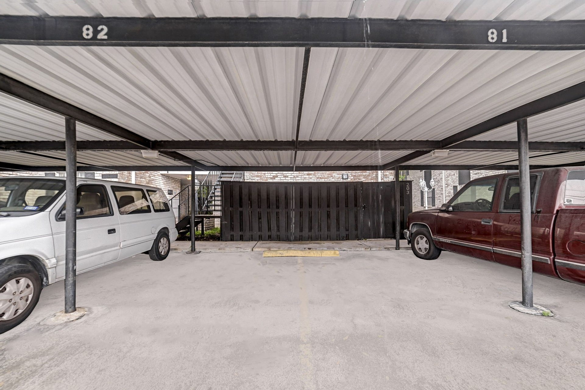 7900 Westheimer Road, #202, Houston, TX 77063 Covered parking area with designated spaces provides convenient and sheltered vehicle storage.