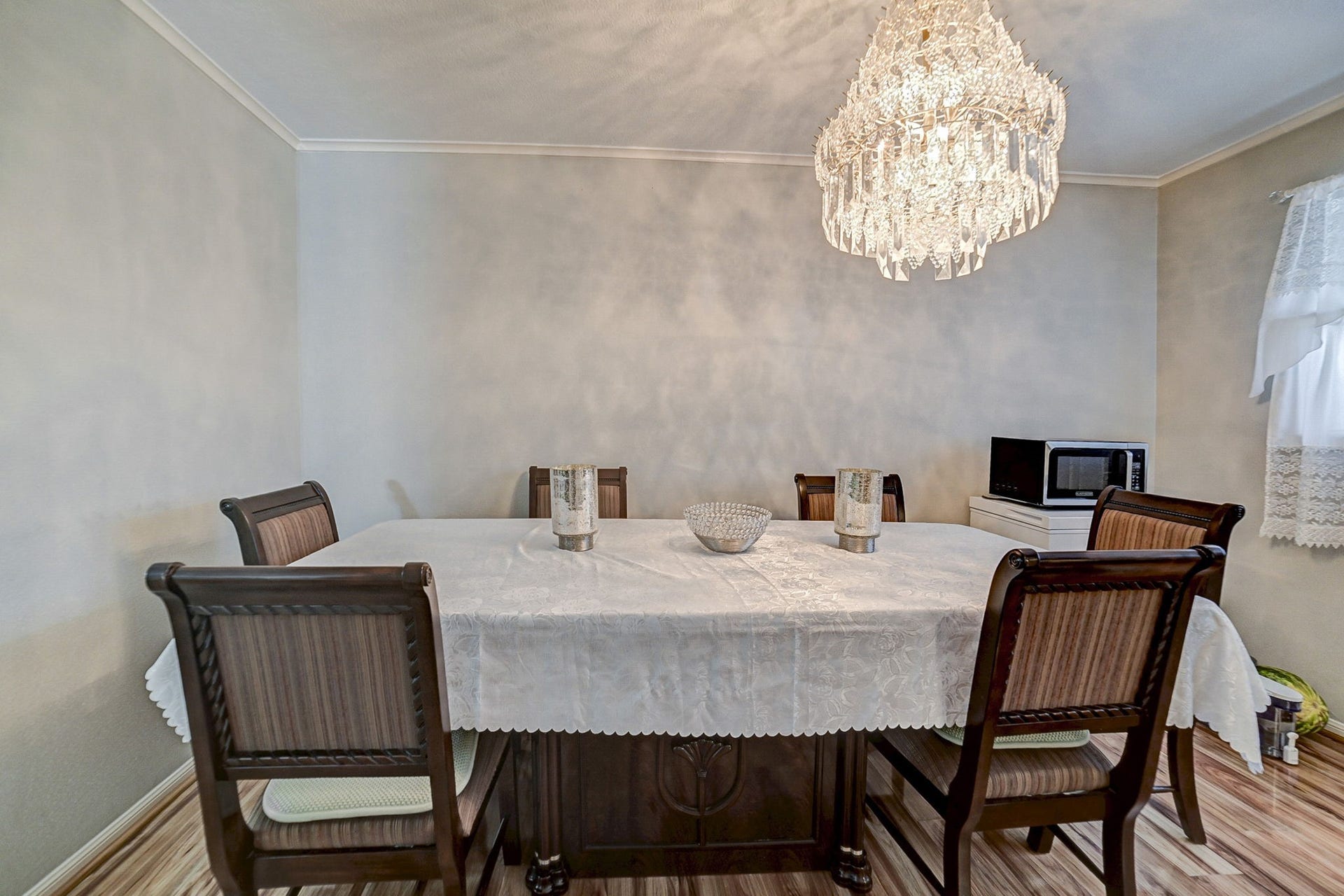 7900 Westheimer Road, #202, Houston, TX 77063 Elegant dining room featuring a sophisticated chandelier, classic table setting with a lace tablecloth, and cozy wooden chairs, perfect for intimate gatherings.