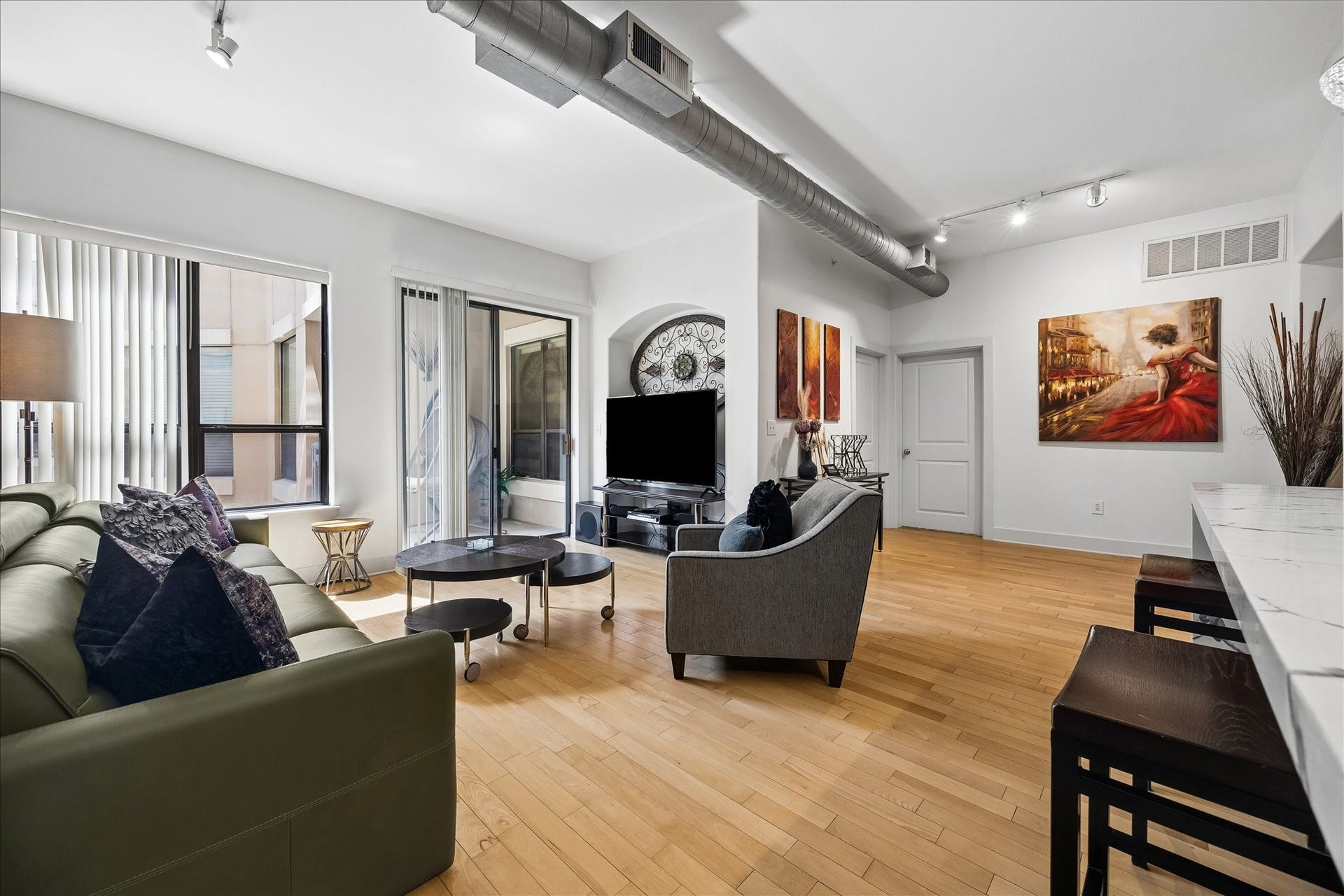 1901 Post Oak Boulevard, #3216, Houston, TX 77056 Spacious living area with hardwood floors and access to the covered balcony.