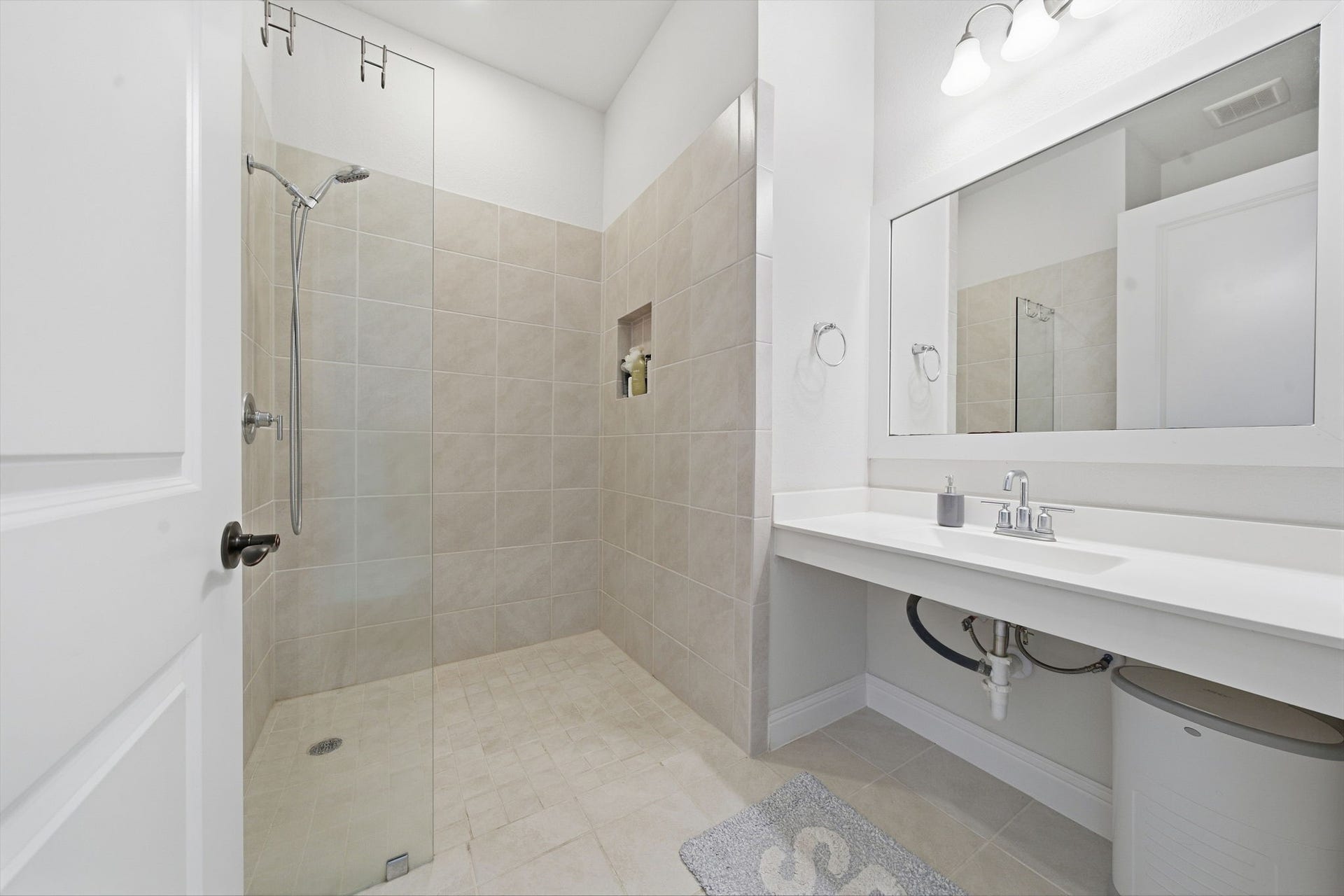 15107 Red Buckeye Drive, Cypress, TX 77433 Second full bath down with a 60"x36" curbless mudset roll-in shower and open knee-space vanity-designed for wheelchair ease and multi-generational living
