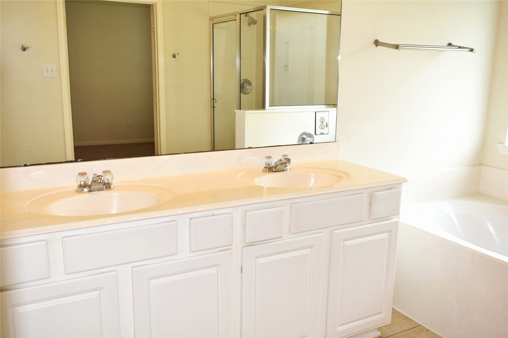 4822 Harbor Glen Lane, Houston, TX 77084 Bright bathroom featuring a double vanity with sleek faucets, a glass-enclosed shower, and a relaxing soaking tub.