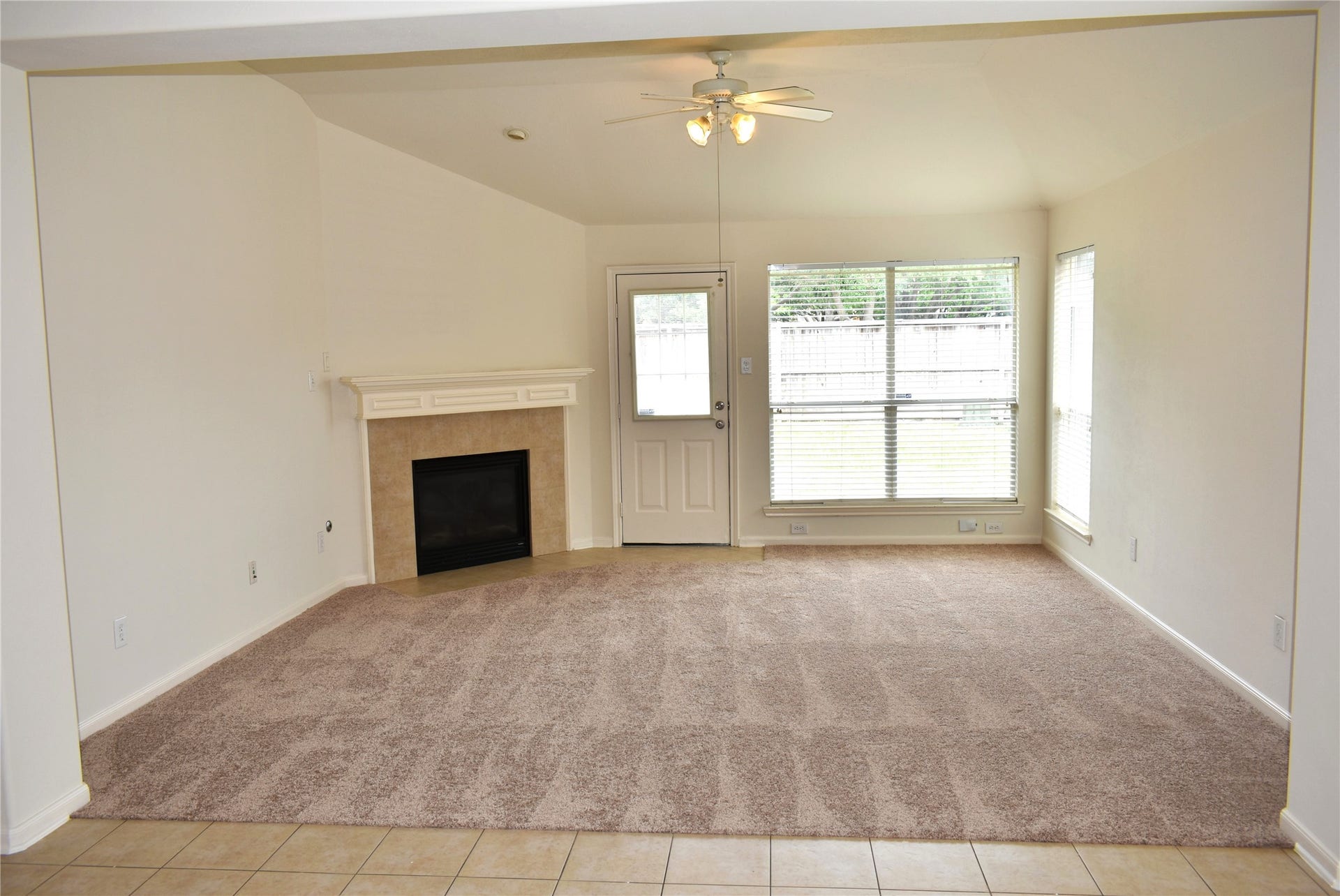 4822 Harbor Glen Lane, Houston, TX 77084 Spacious living area featuring a cozy fireplace, plush carpet, and large windows offering ample natural light.